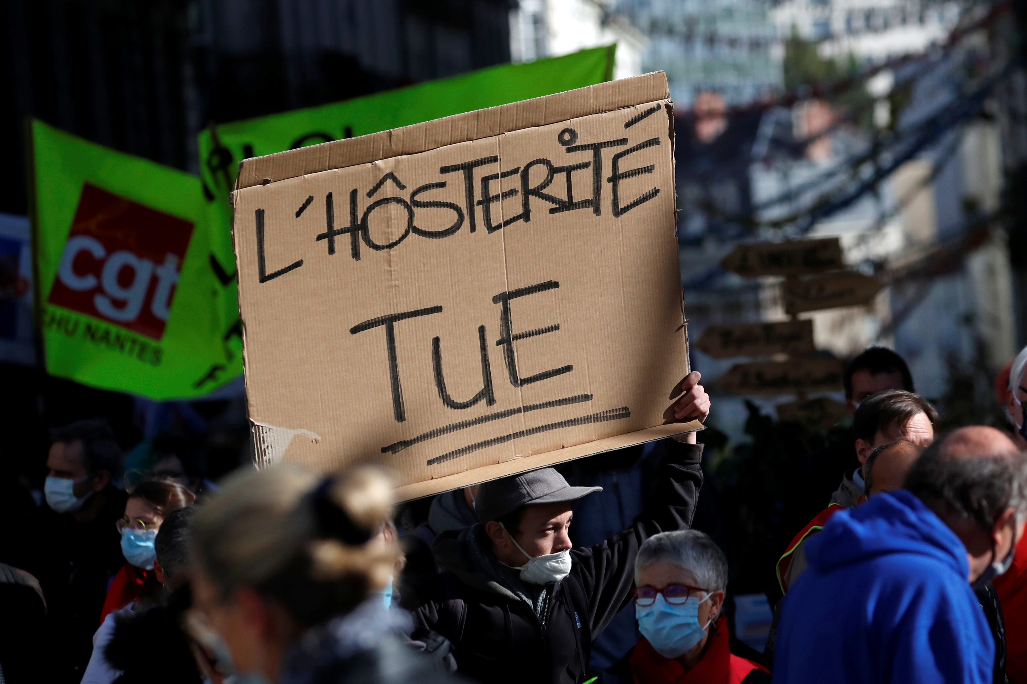 French health workers and labour union members attend a protest in Nantes as part of a nationwide day of actions to urge the government to increase staff as hospitals fill once again with COVID-19 patients, France, October 15, 2020. The slogan reads "Austerity kills". REUTERS/Stephane Mahe