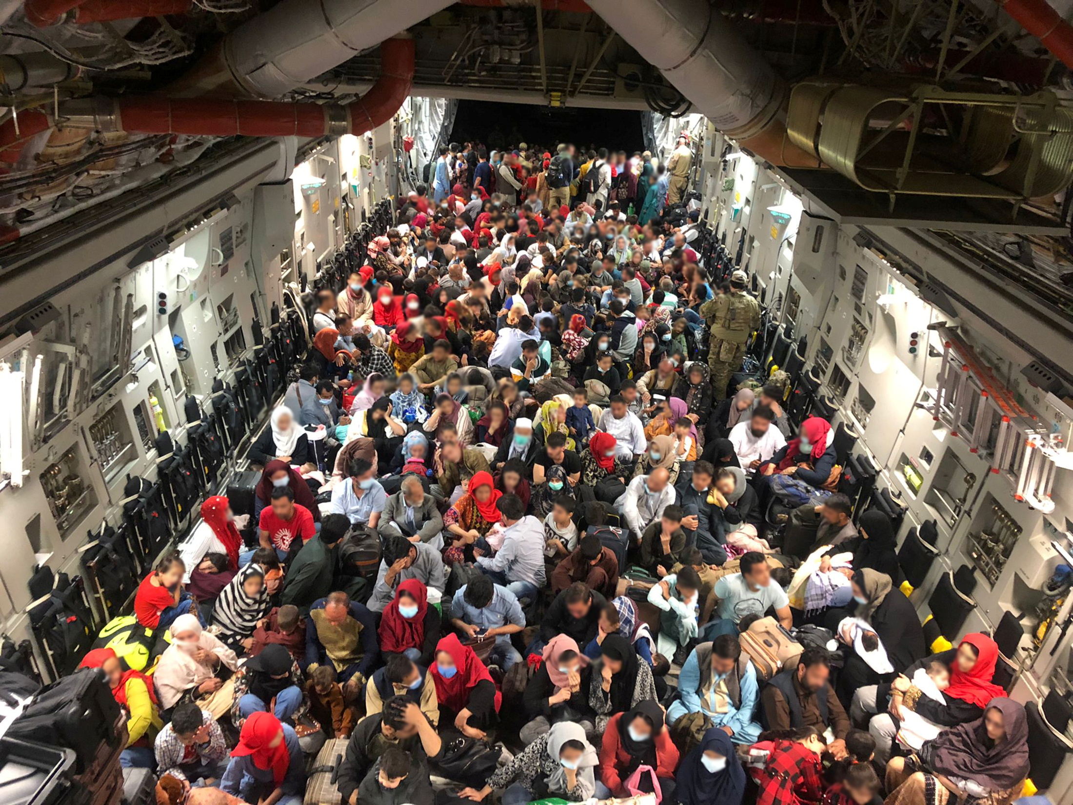 Evacuees termed Canadian Entitled Persons sit in a Royal Canadian Air Force (RCAF) C-177 Globemaster III transport plane for their flight to Canada from Kabul, Afghanistan, August 23, 2021. Picture taken August 23, 2021.
