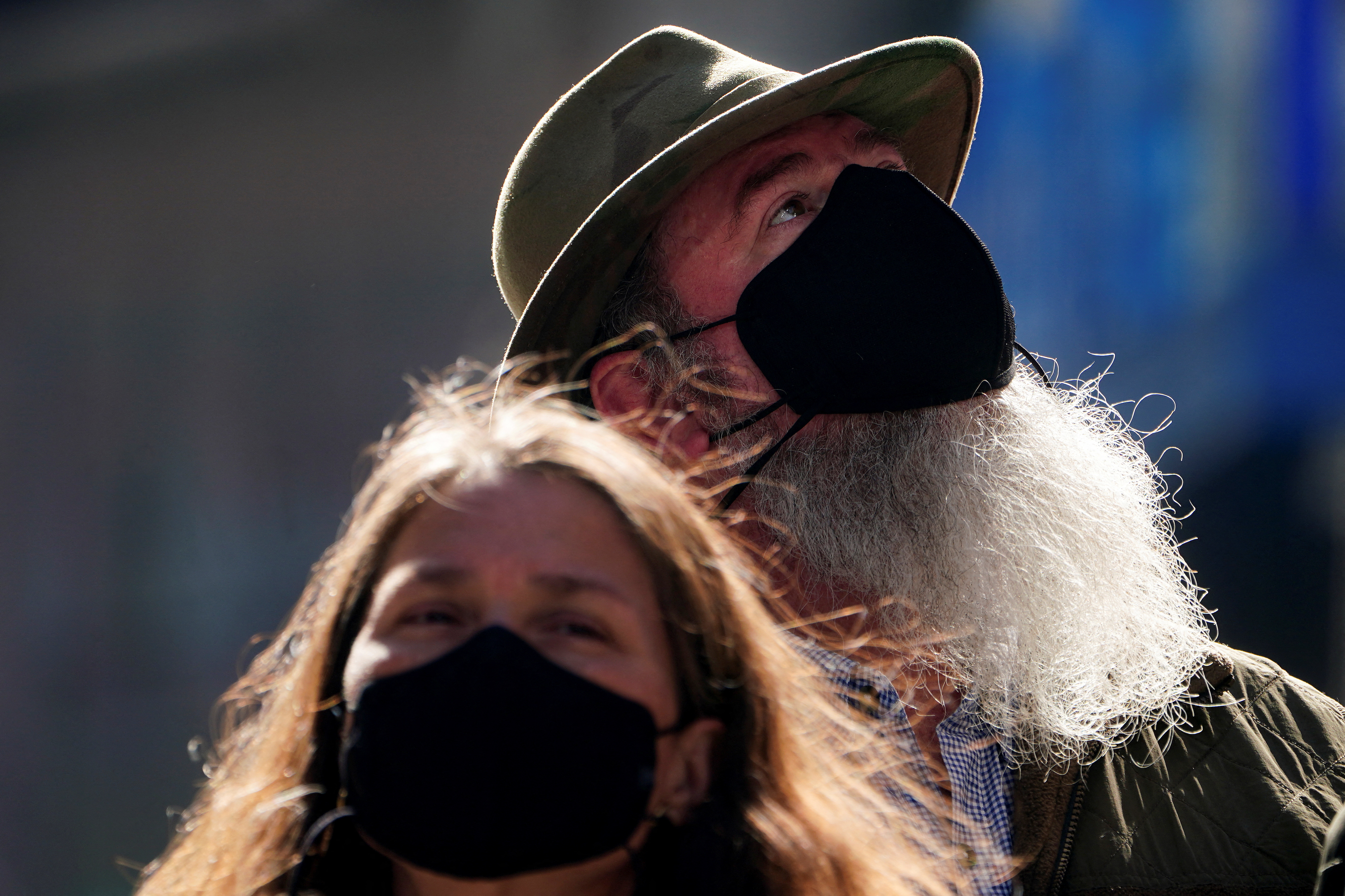 People wearing masks walk through Times Square