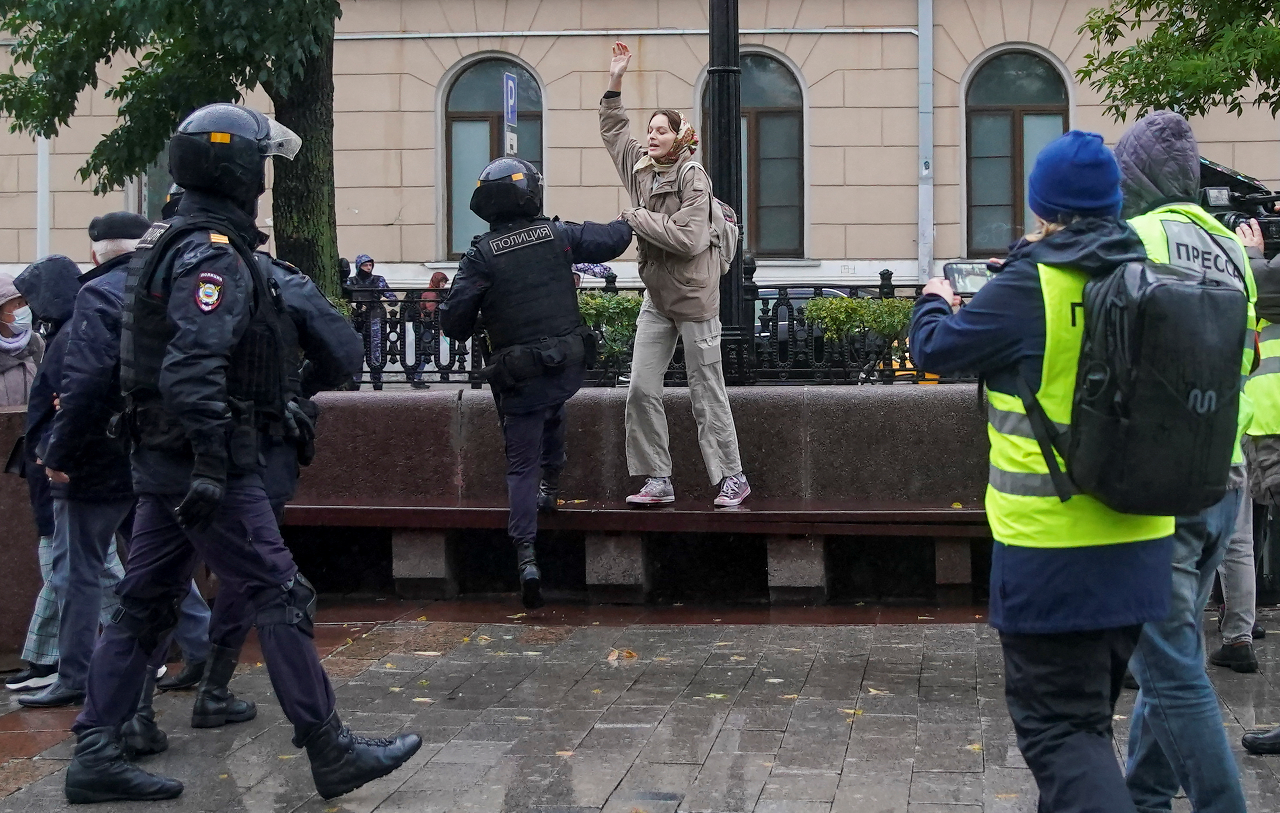A Russian law enforcement officer detains a person during a rally.