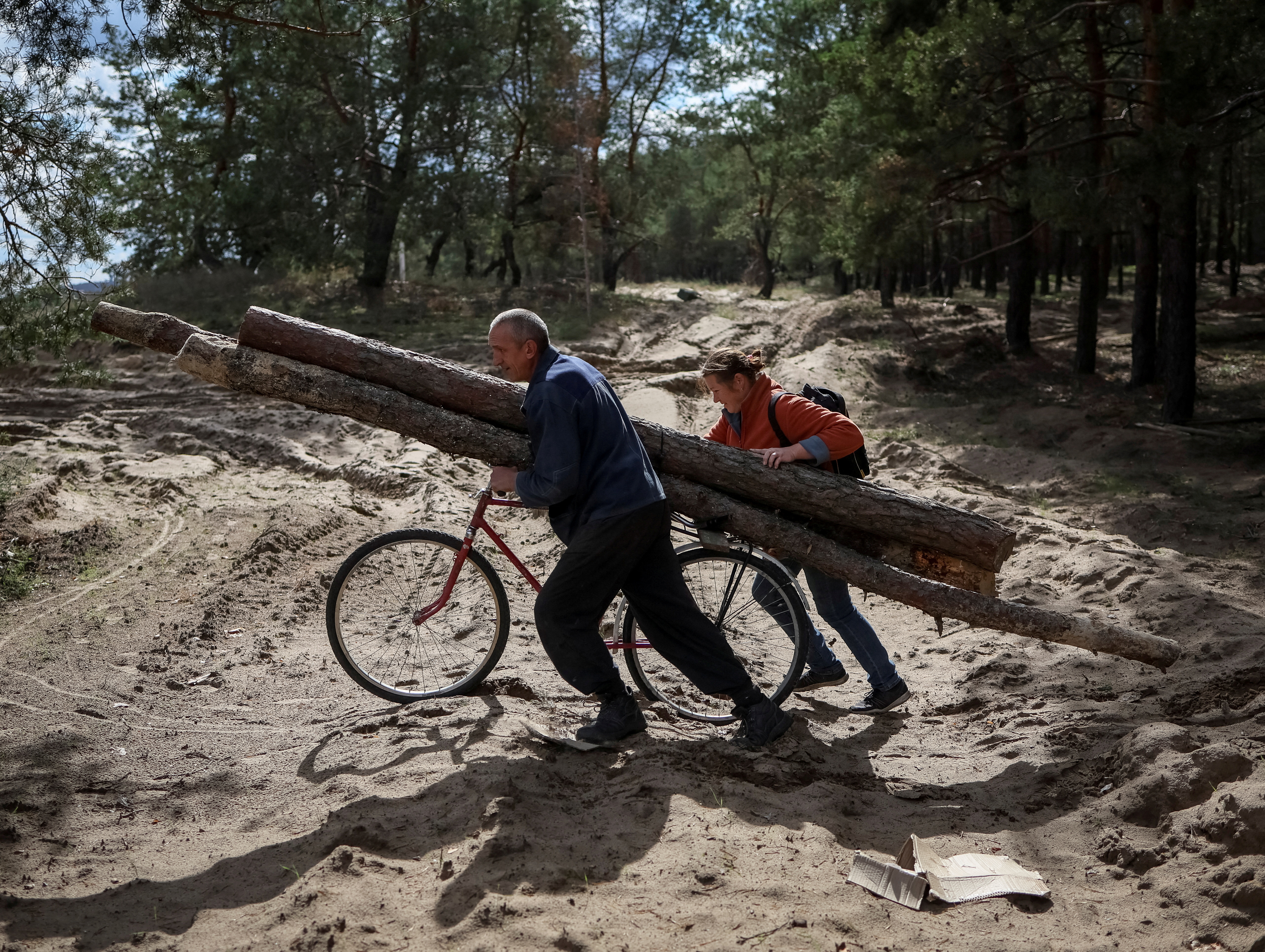 Local residents collect firewood from abandoned blindages of the Russian army to heat their homes, as they have no electricity,
