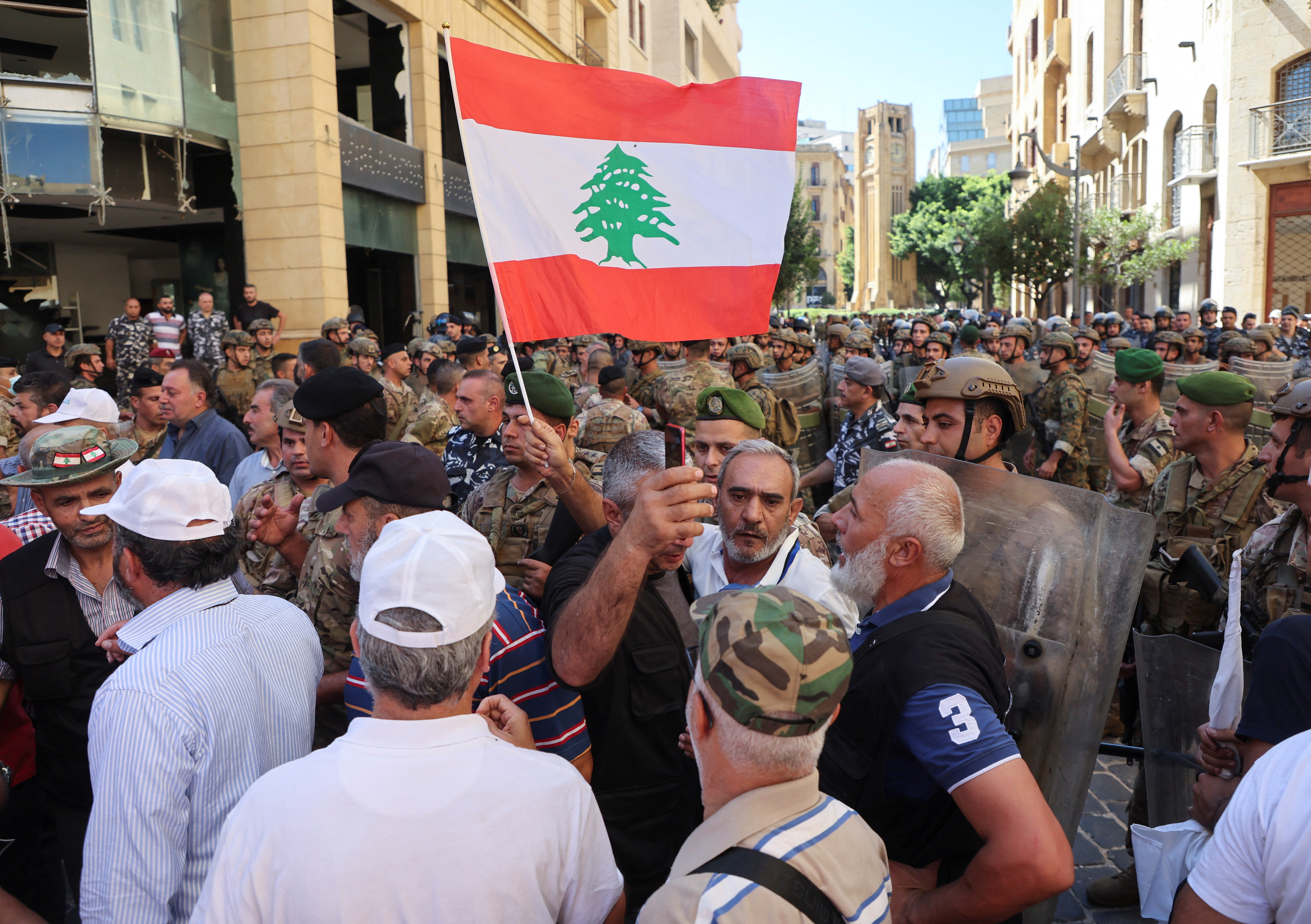 A demonstrator holds a Lebanese flag