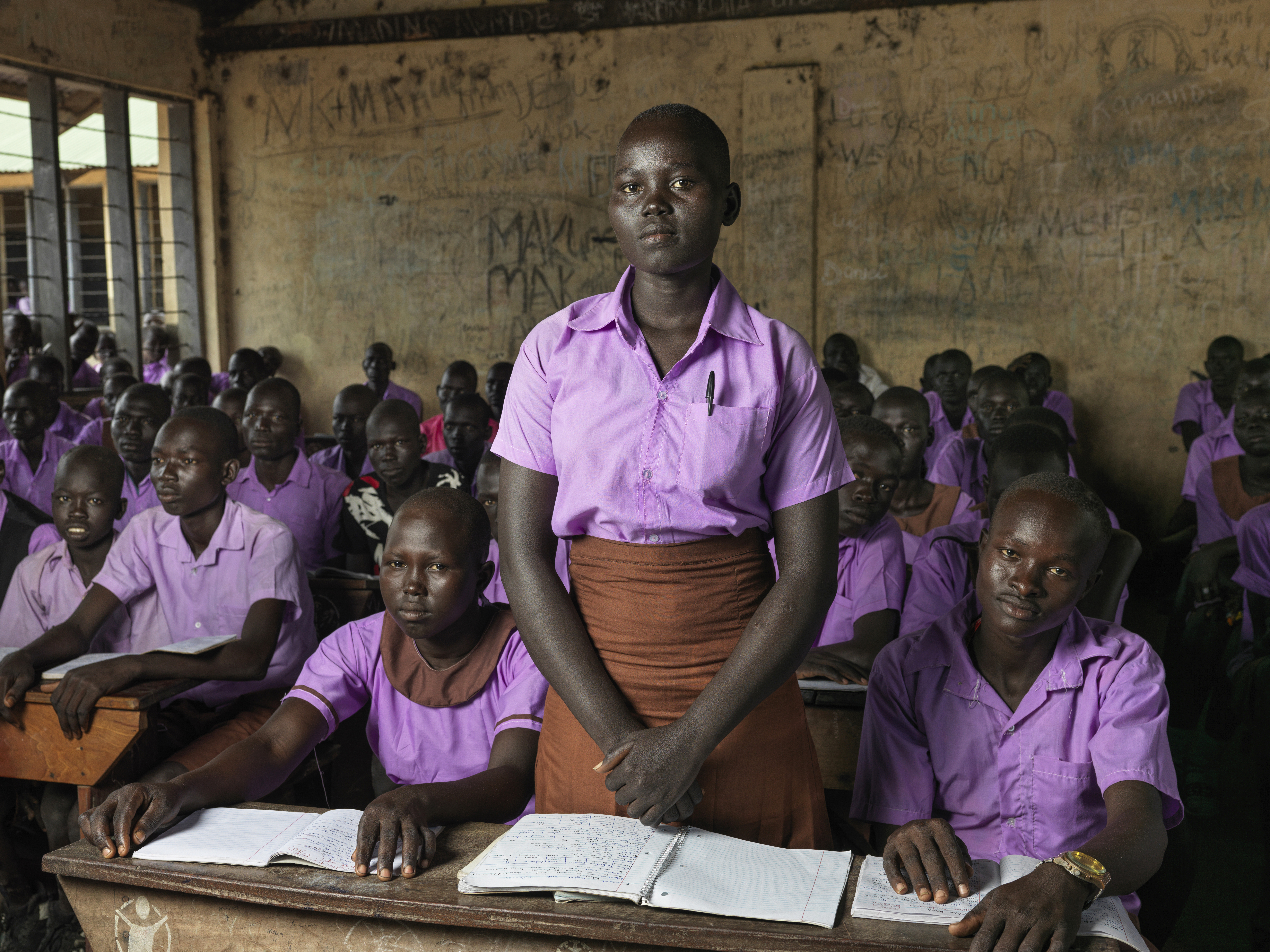 A photo of Hellena standing in a classroom of students sitting.
