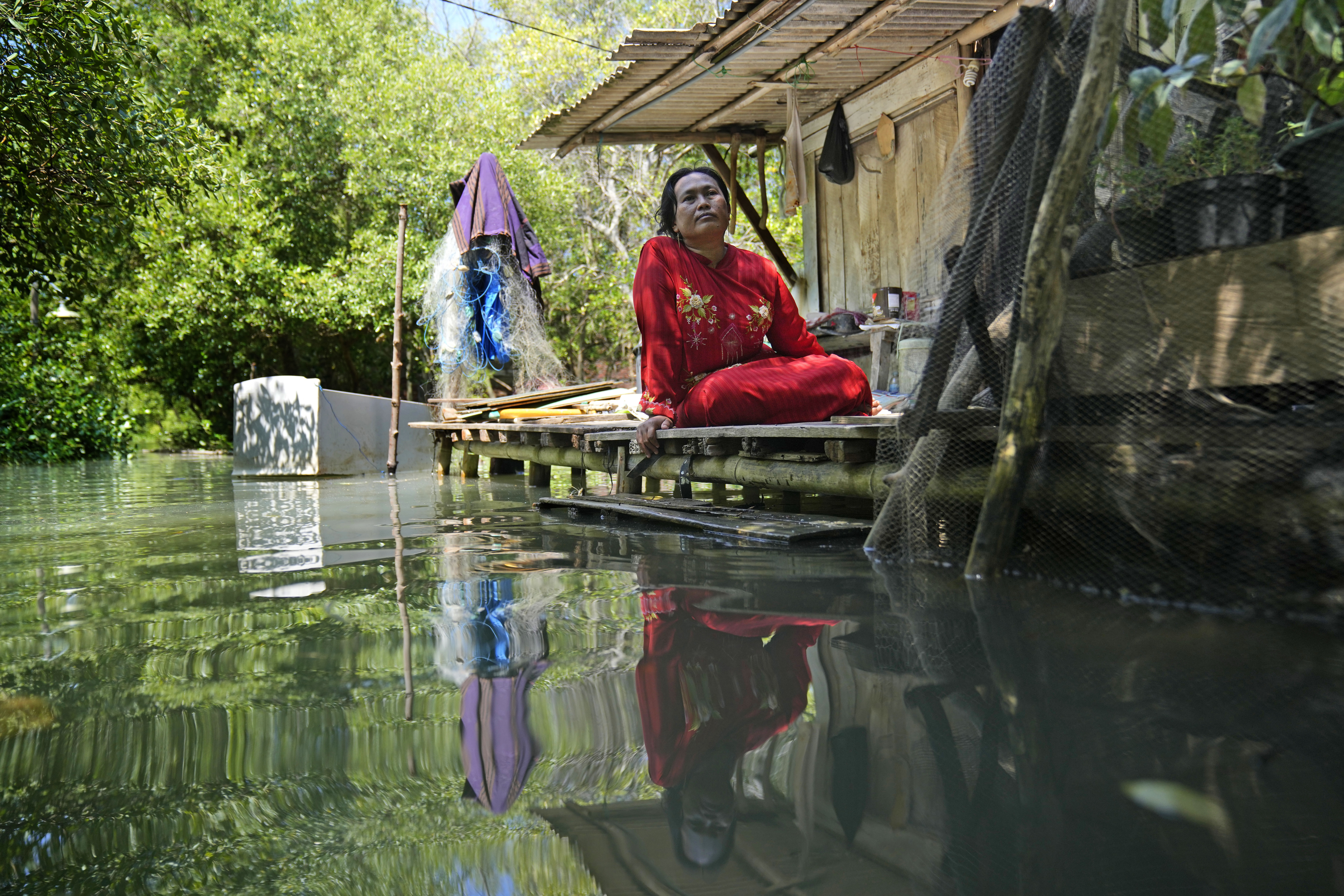 Munadiroh sits outside her home in Mondoliko