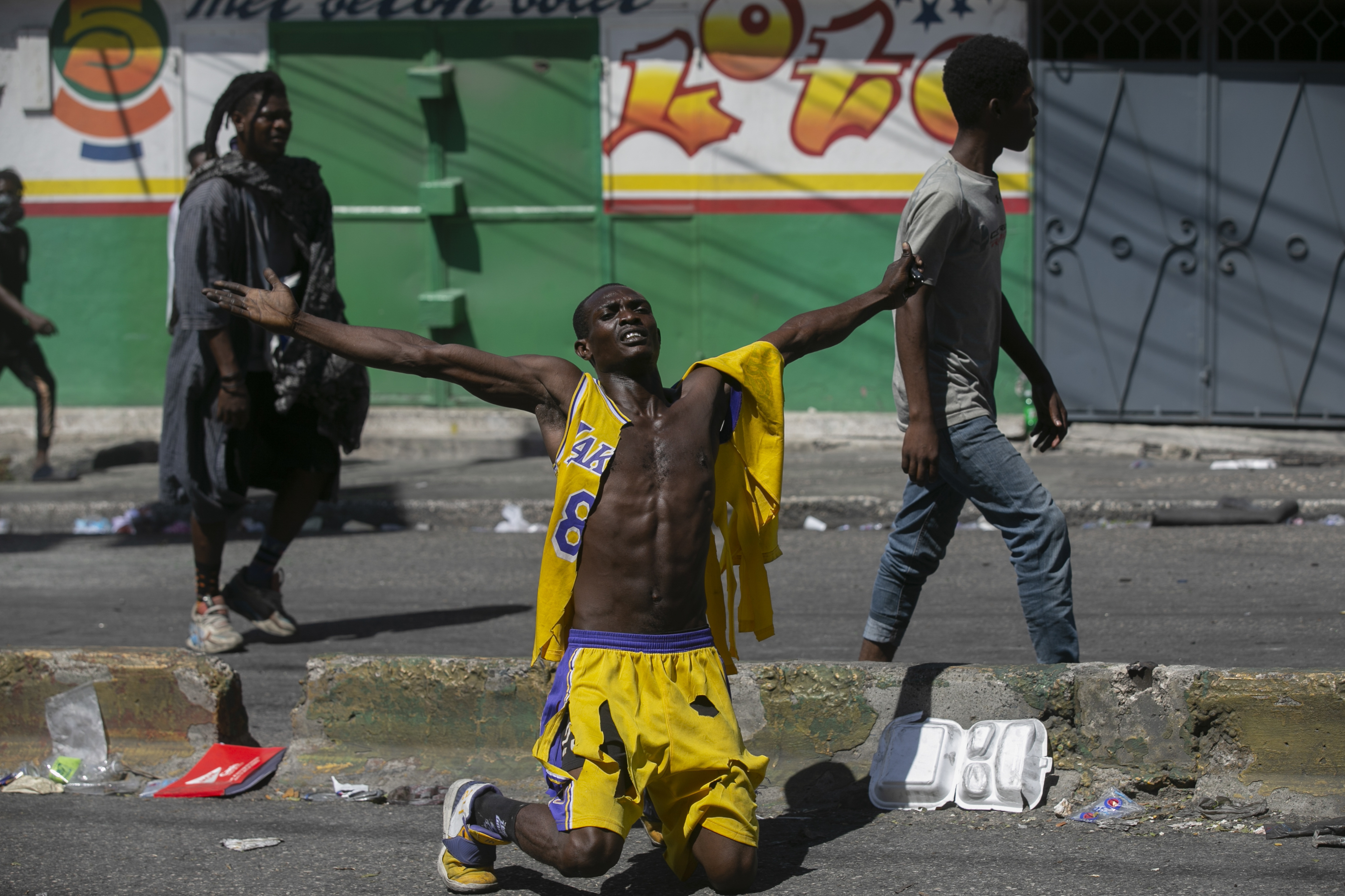 A protester kneels in Haiti