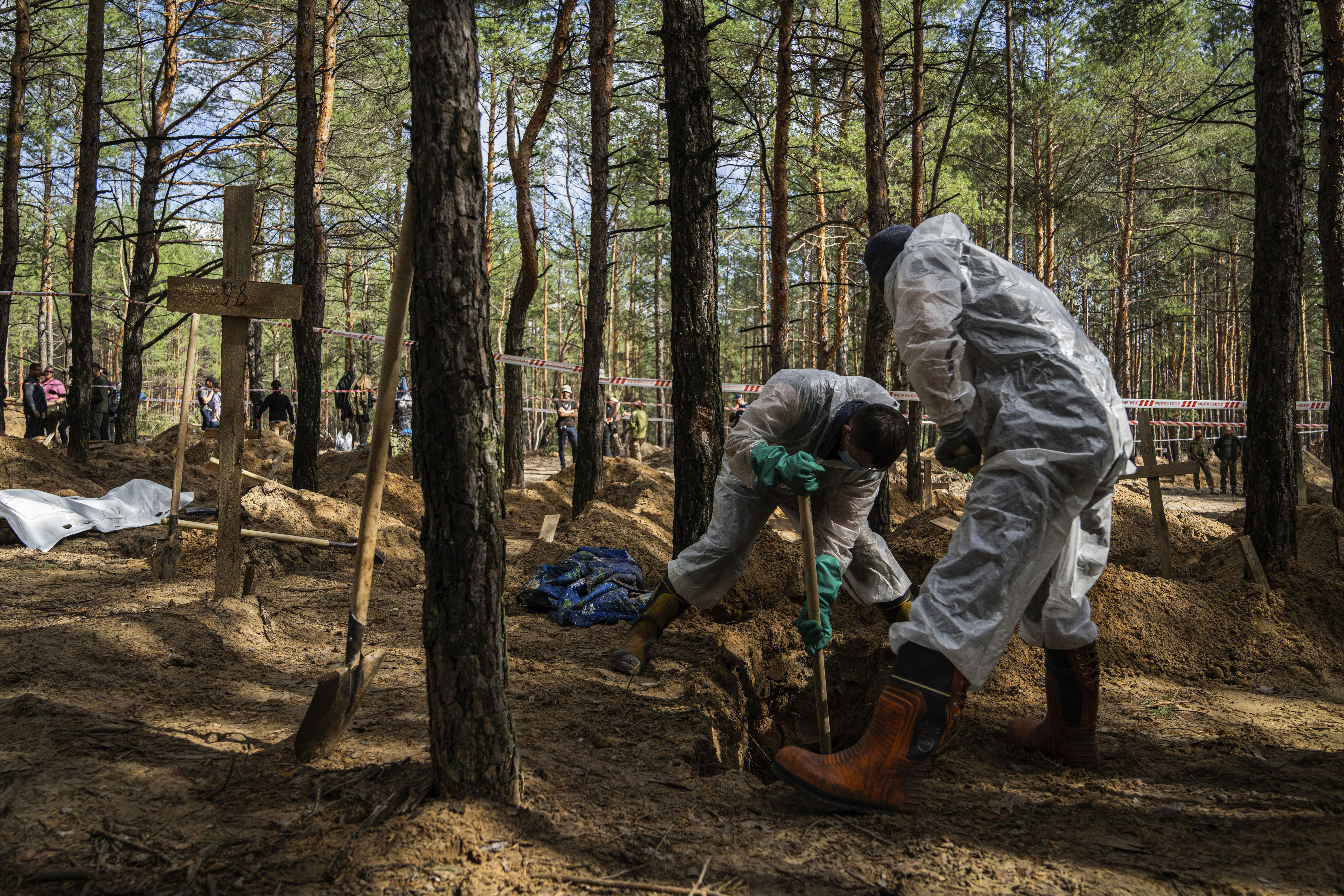 Emergency workers dig a grave of a civilian