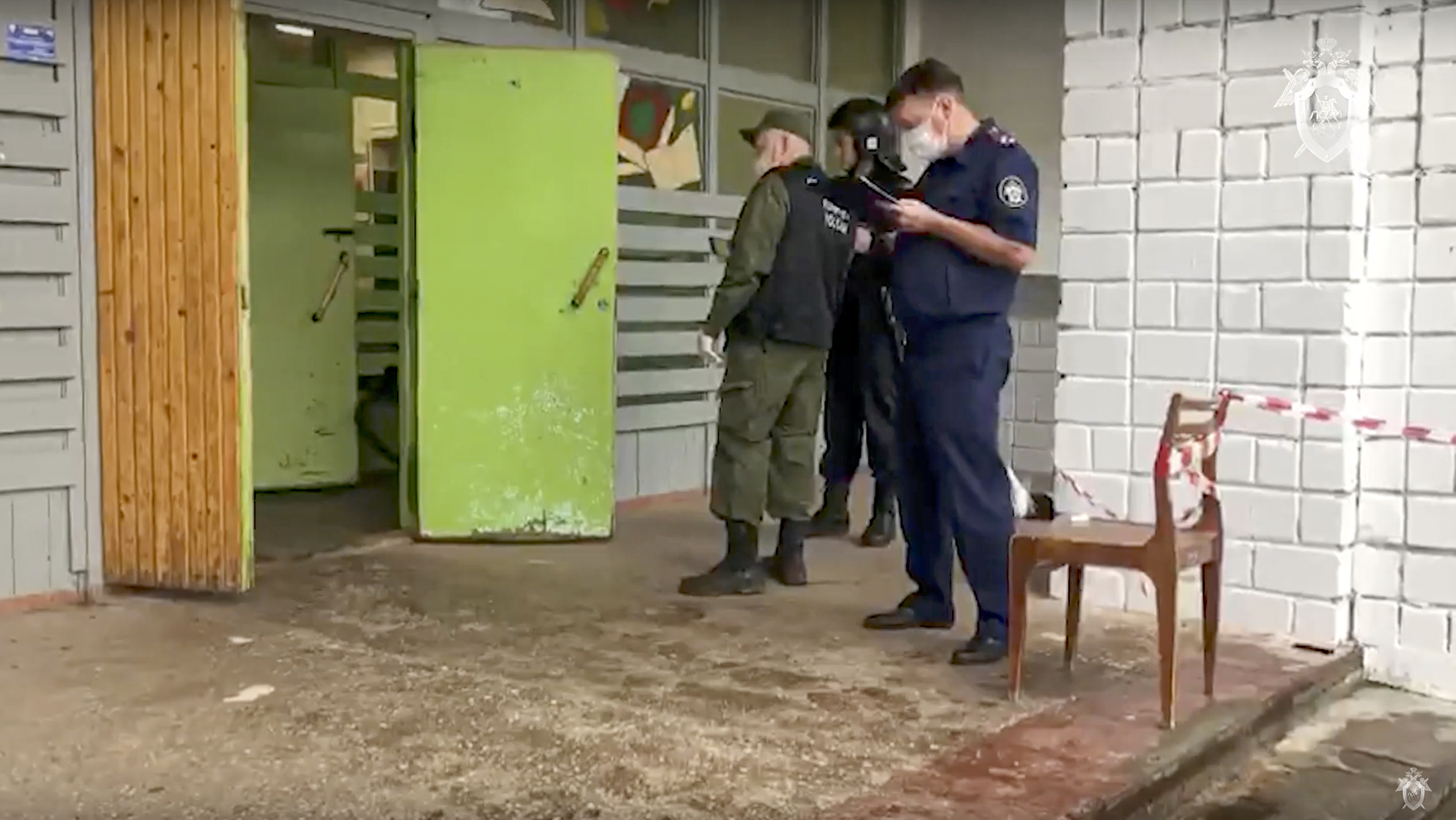 Employees of the Russian Investigative Committee work at the scene of a shooting .