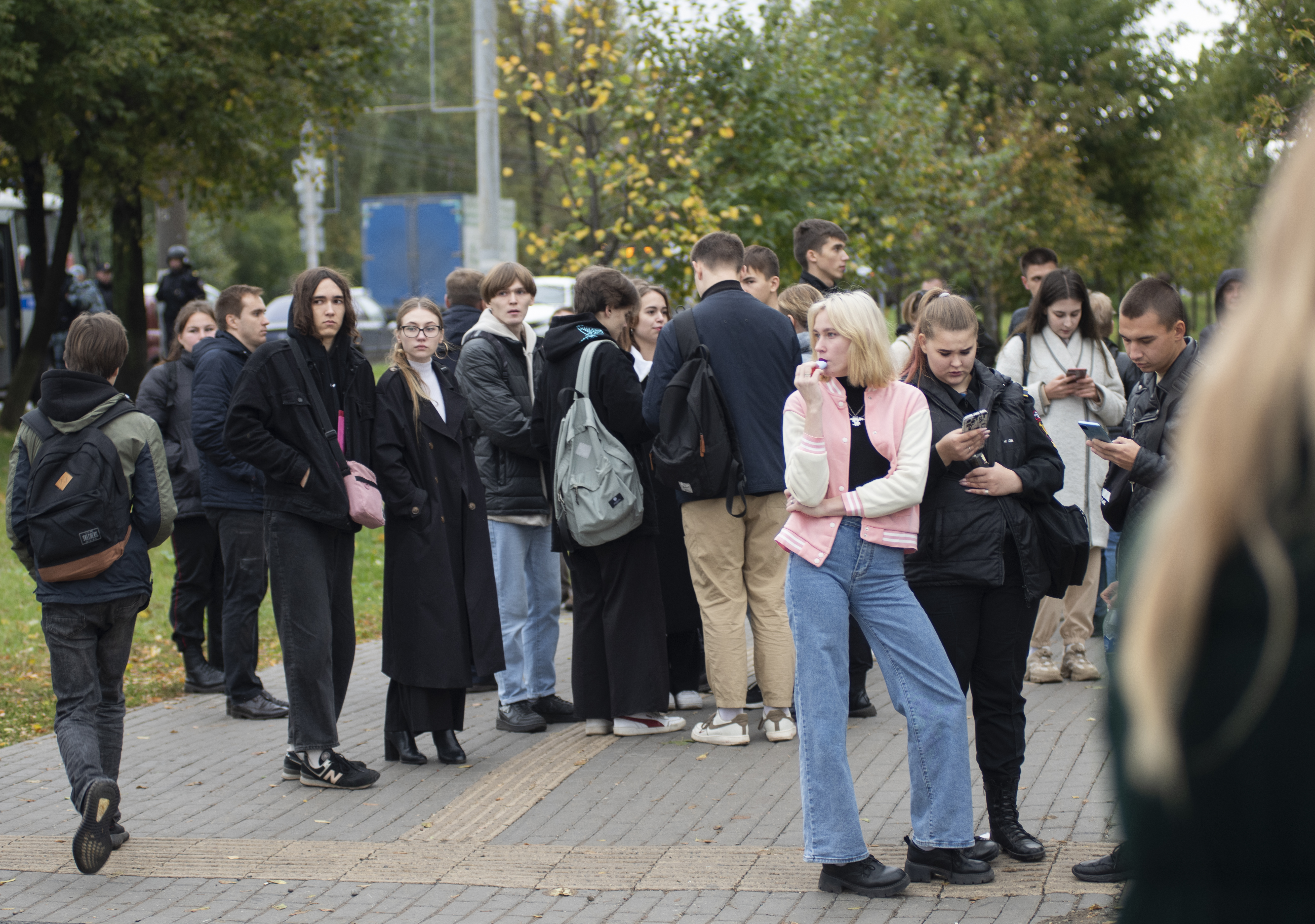 Pupils evacuated from the classes due a school shooting stand on the sidewalk in front of school 88 in Izhevsk.