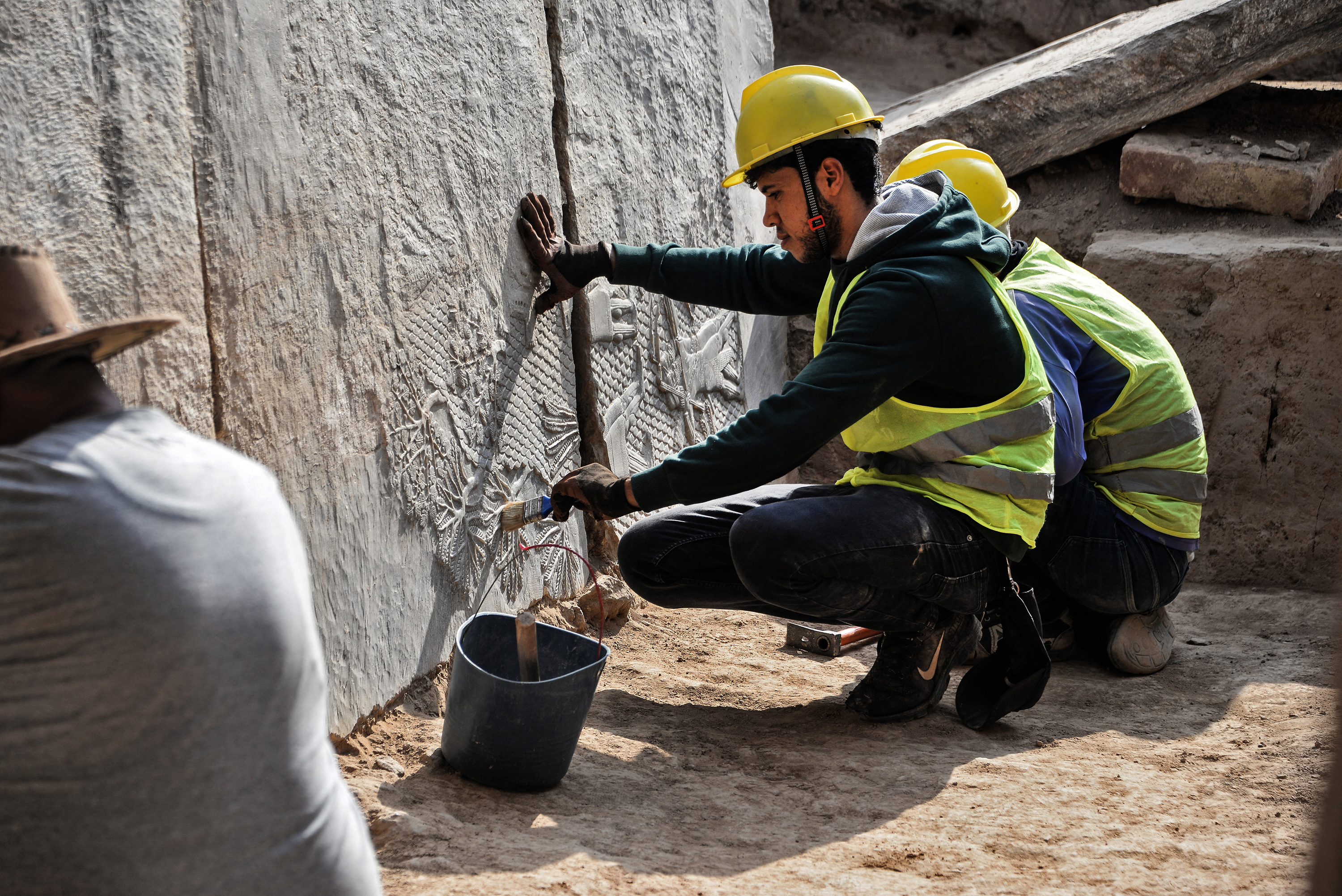 Iraqi workers excavate a rock-carving relief recently found at the Mashki Gate, one of the monumental gates to the ancient Assyrian city of Nineveh, on the outskirts of what is today the northern Iraqi city of Mosul