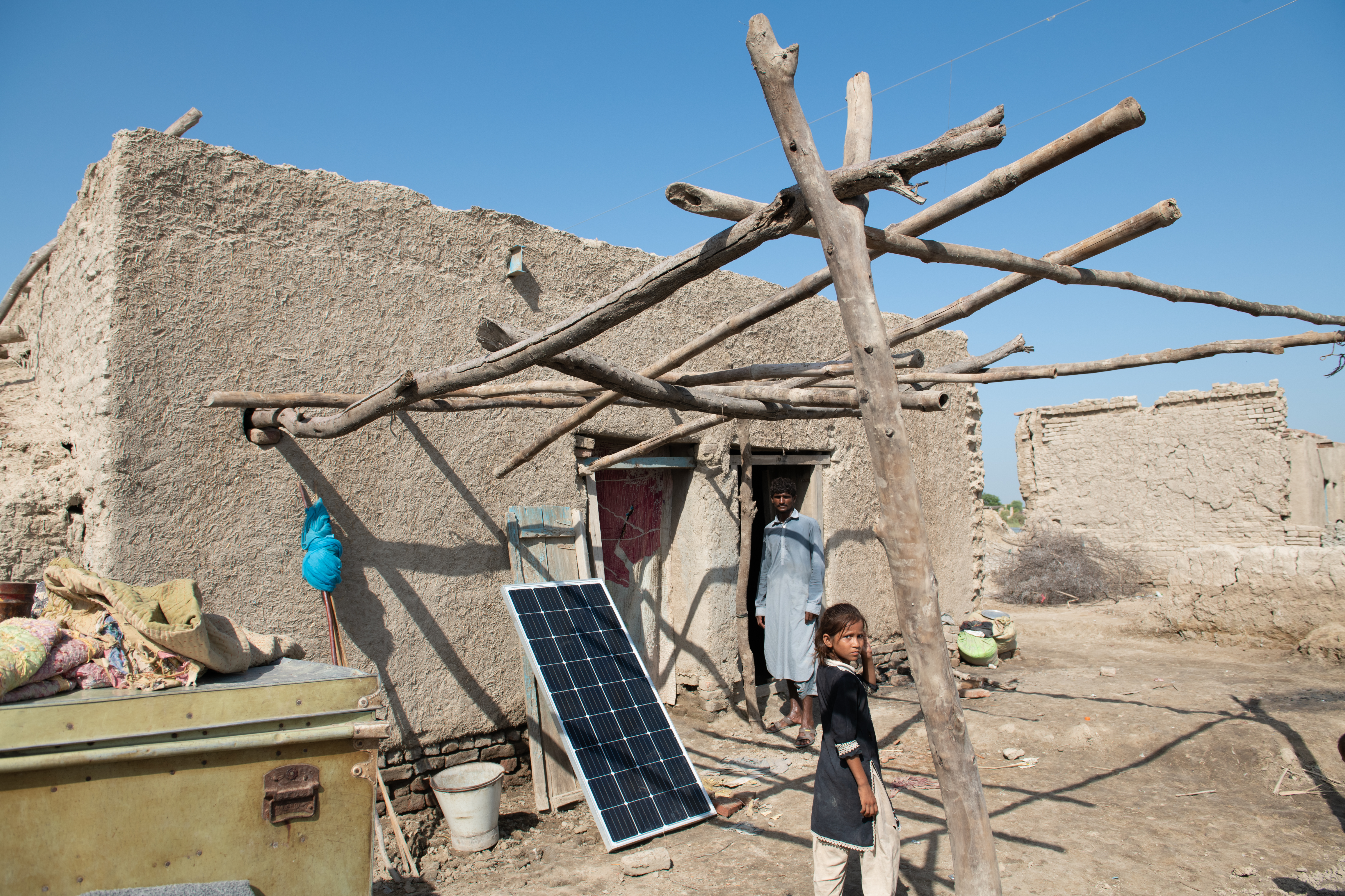 Flood-affected areas cut off from the power grid have no reliable supply of electricity. Solar panels are seen in some areas. The absence of carbon-emitting vehicles reminds us that those contributing the least to climate change are impacted the most.