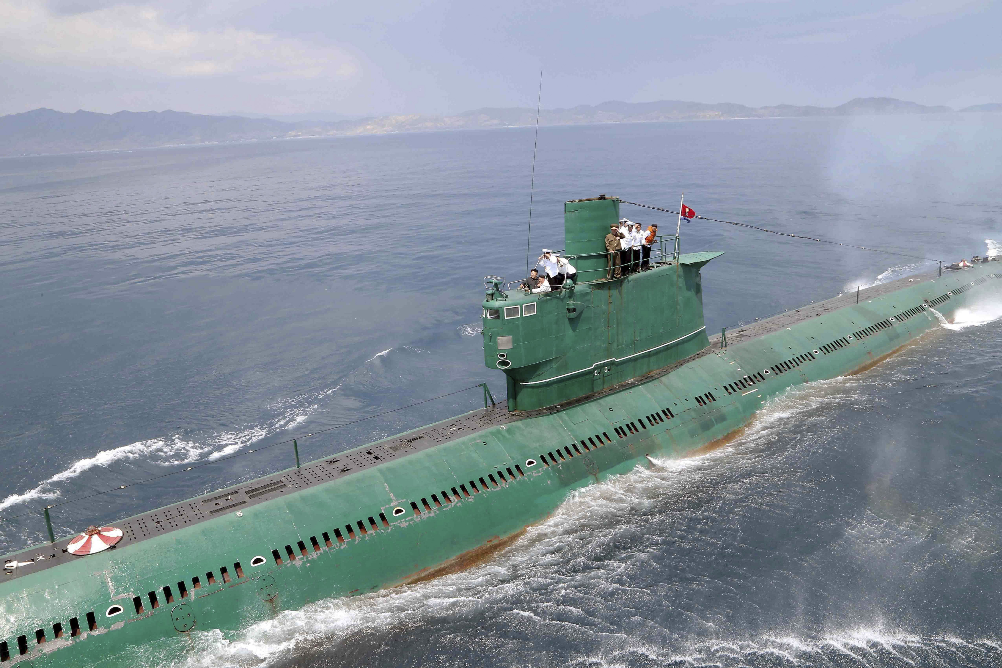 north Korean leader Kim Jong Un stands on the conning tower of a submarine during his inspection of the Korean People's Army Naval Unit 167 in this undated photo released by North Korea's Korean Central News Agency in Pyongyang.