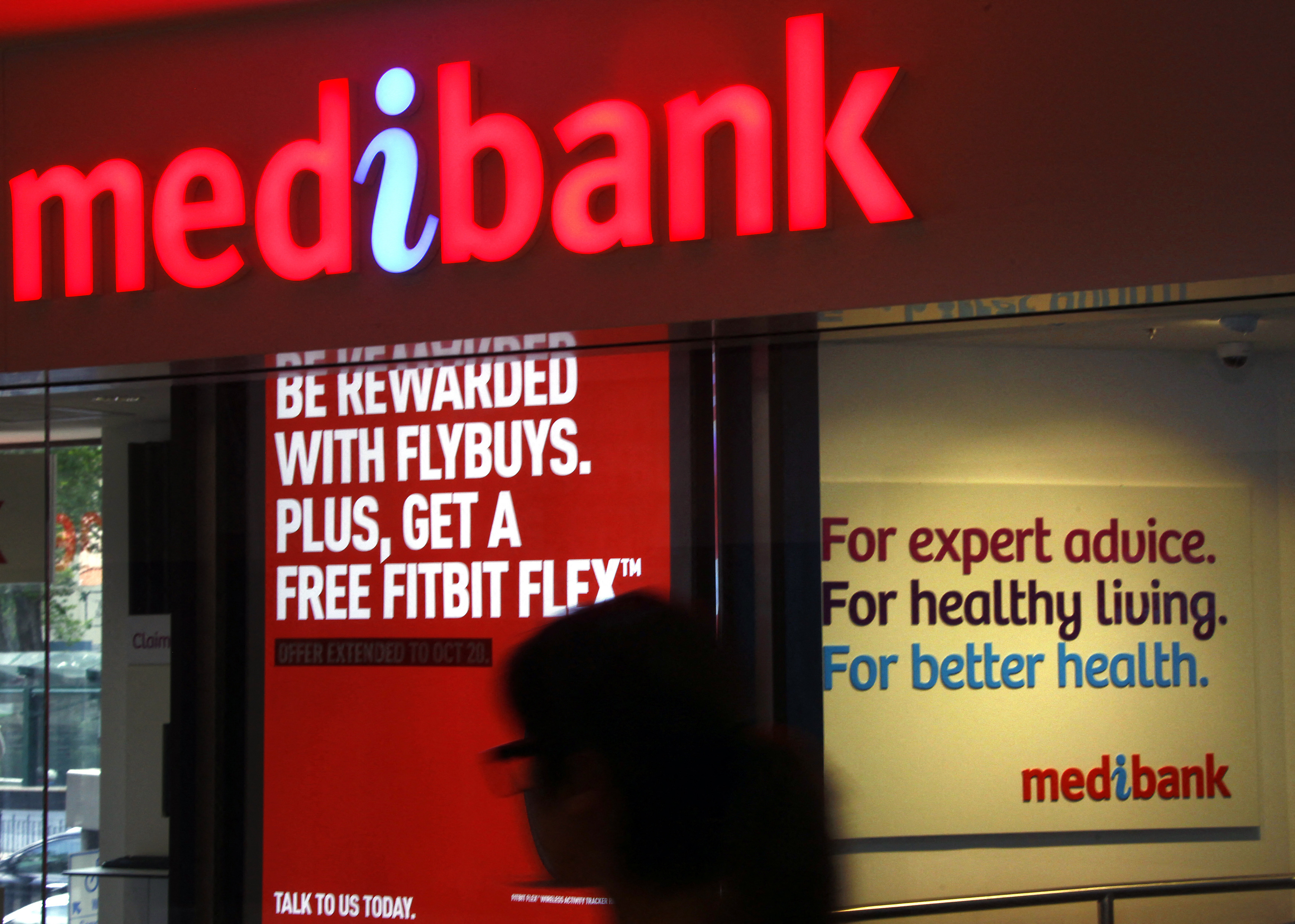 A woman walks past a branch of the Australian health insurer Medibank Private in Sydney, Australia.