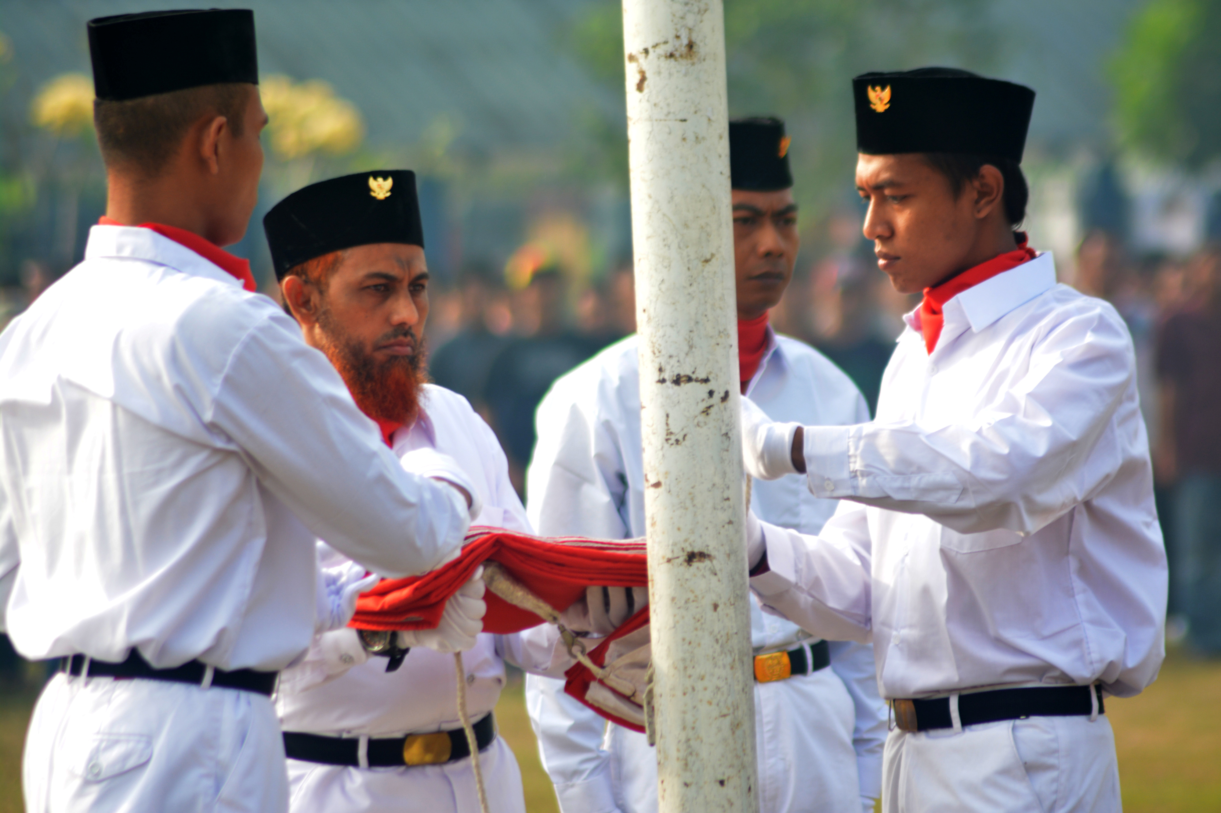 Umar Patek who was convicted over his role in the Bali bombings folding the Indonesian flag and wearing a traditional songkok hat with the Indonesian garuda during a ceremony in prison