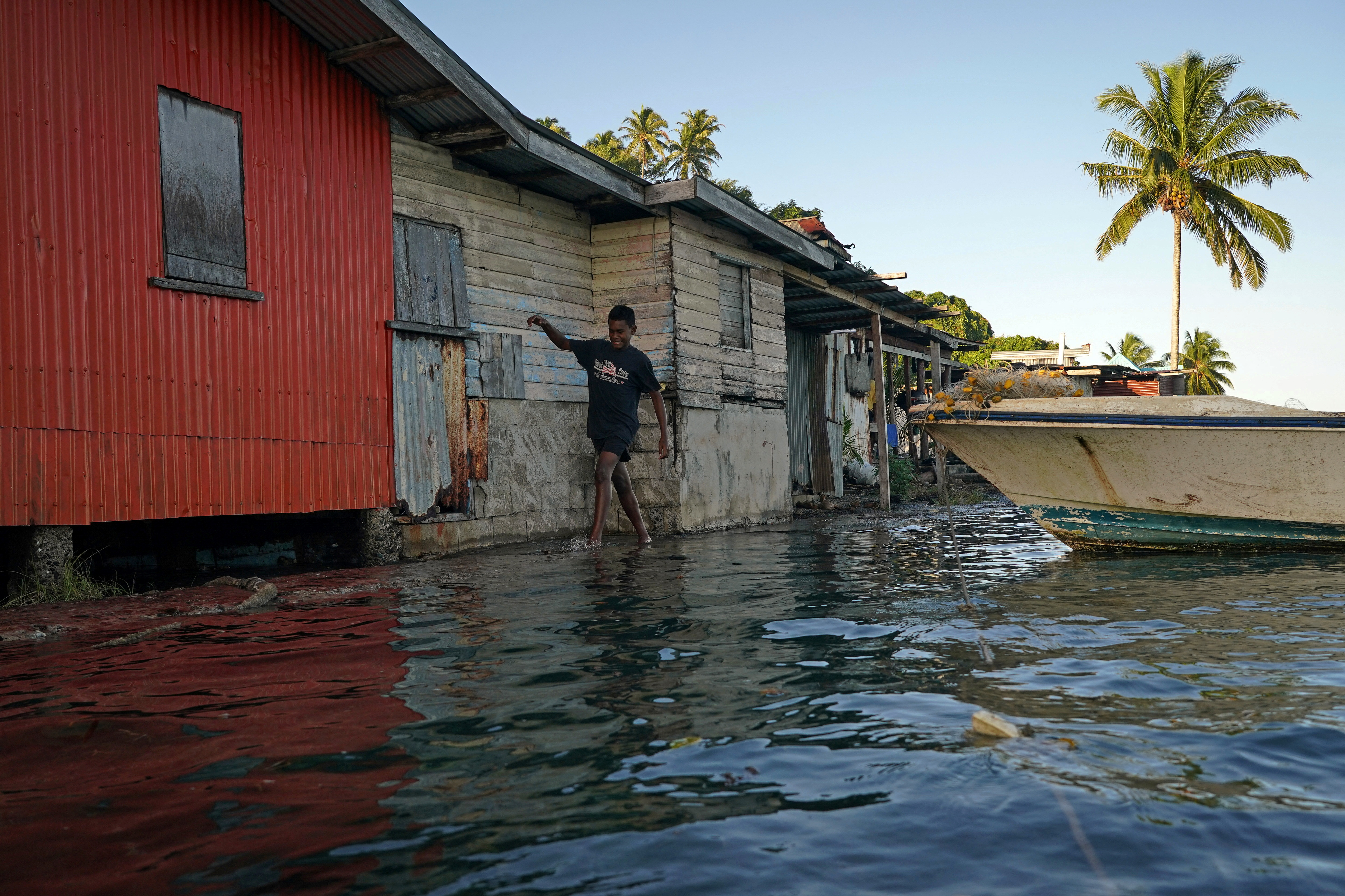 Local boy Ratusela Waqanaceva, 14, wades through seawater flooding in Pakistan
