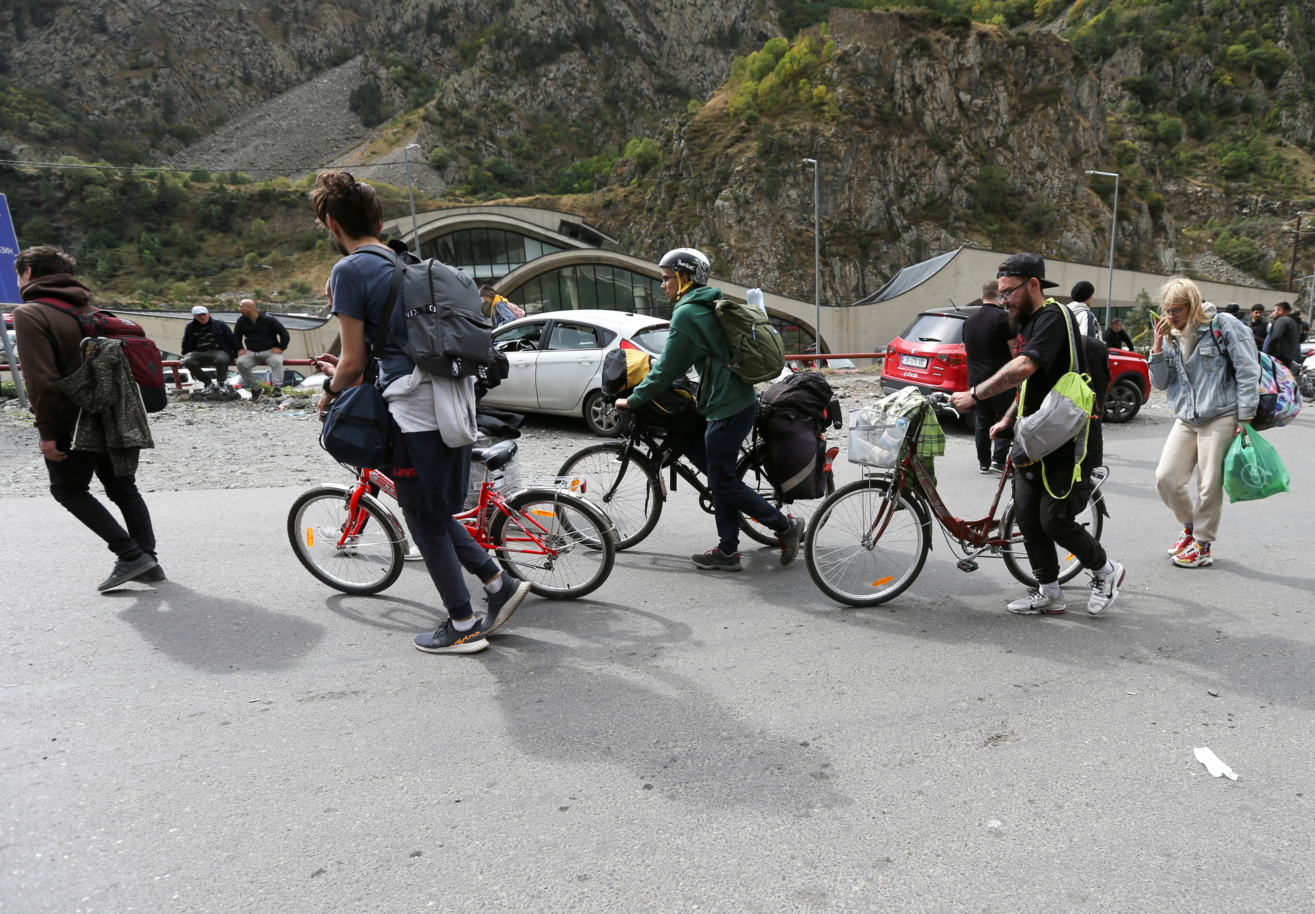 Travellers walk after crossing the border with Russia at the frontier checkpoint Verkhny Lars - Zemo Larsi, Georgia September 28, 2022.