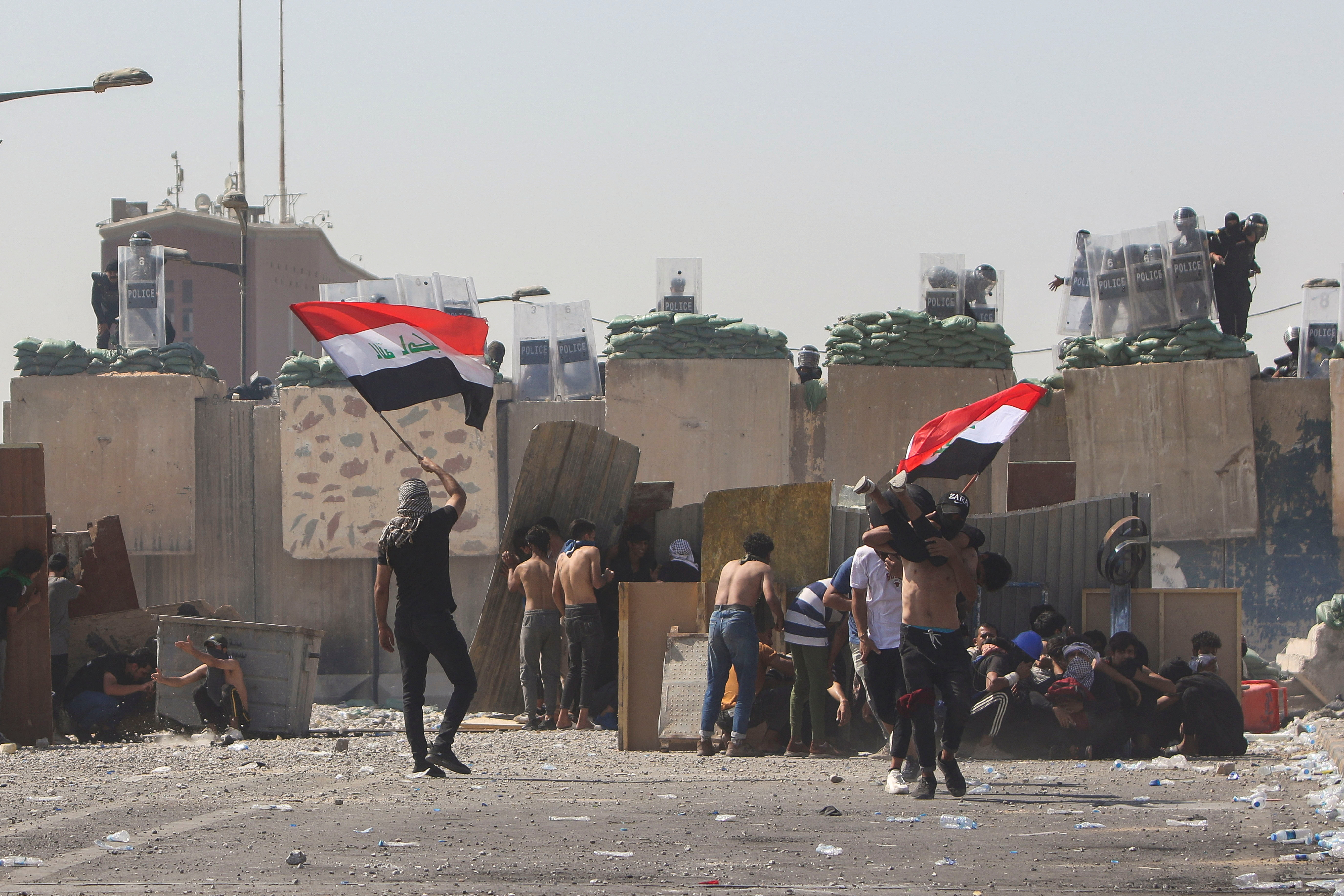 A wounded protester is carried during clashes with Iraqi security forces at a gathering marking the third anniversary of the anti-government protests in Baghdad, Iraq October 1, 2022. REUTERS/Ahmed Saad