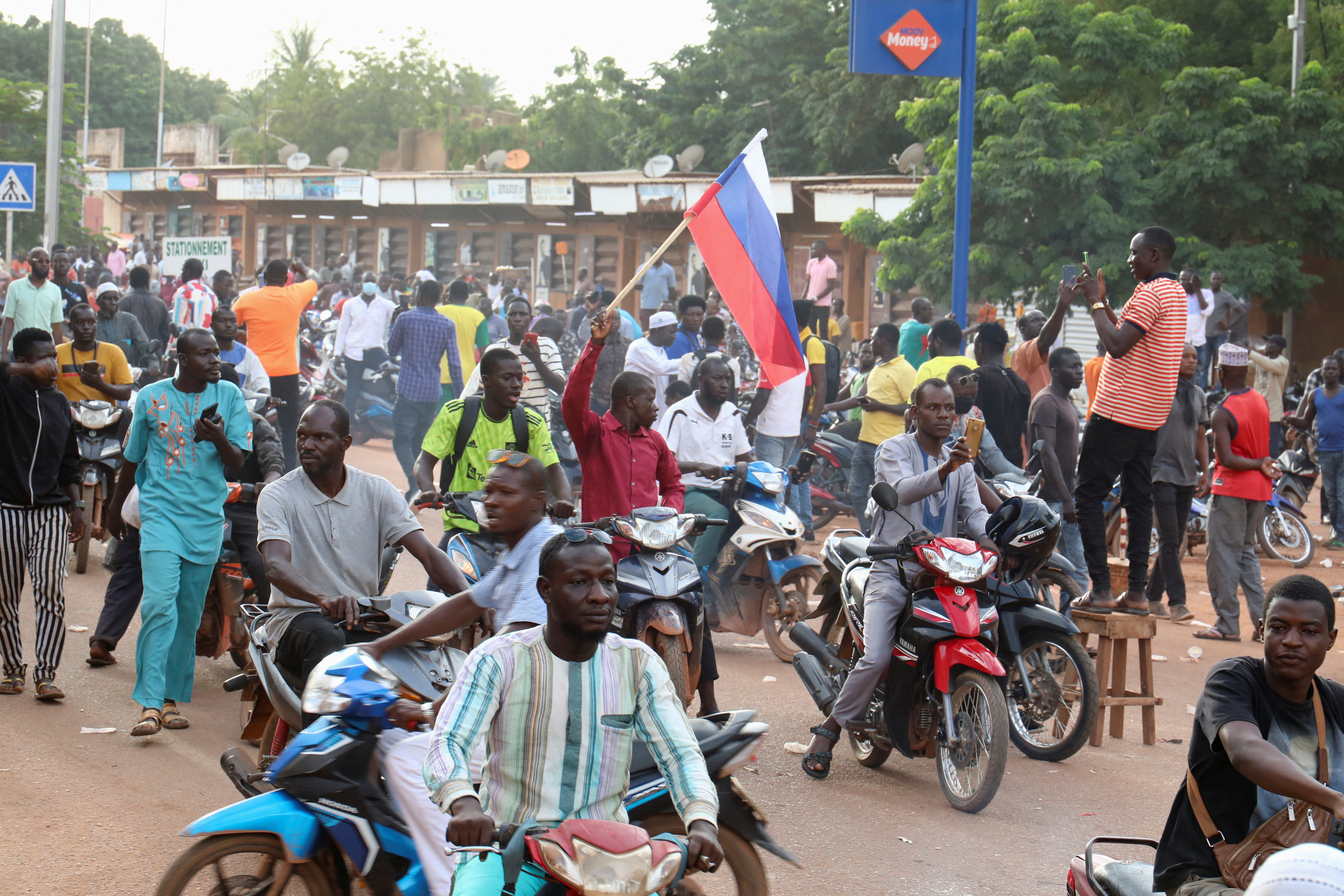 Photo shows a crowd of Burkinabe protesters on a tree-lined street in Ouagadougou