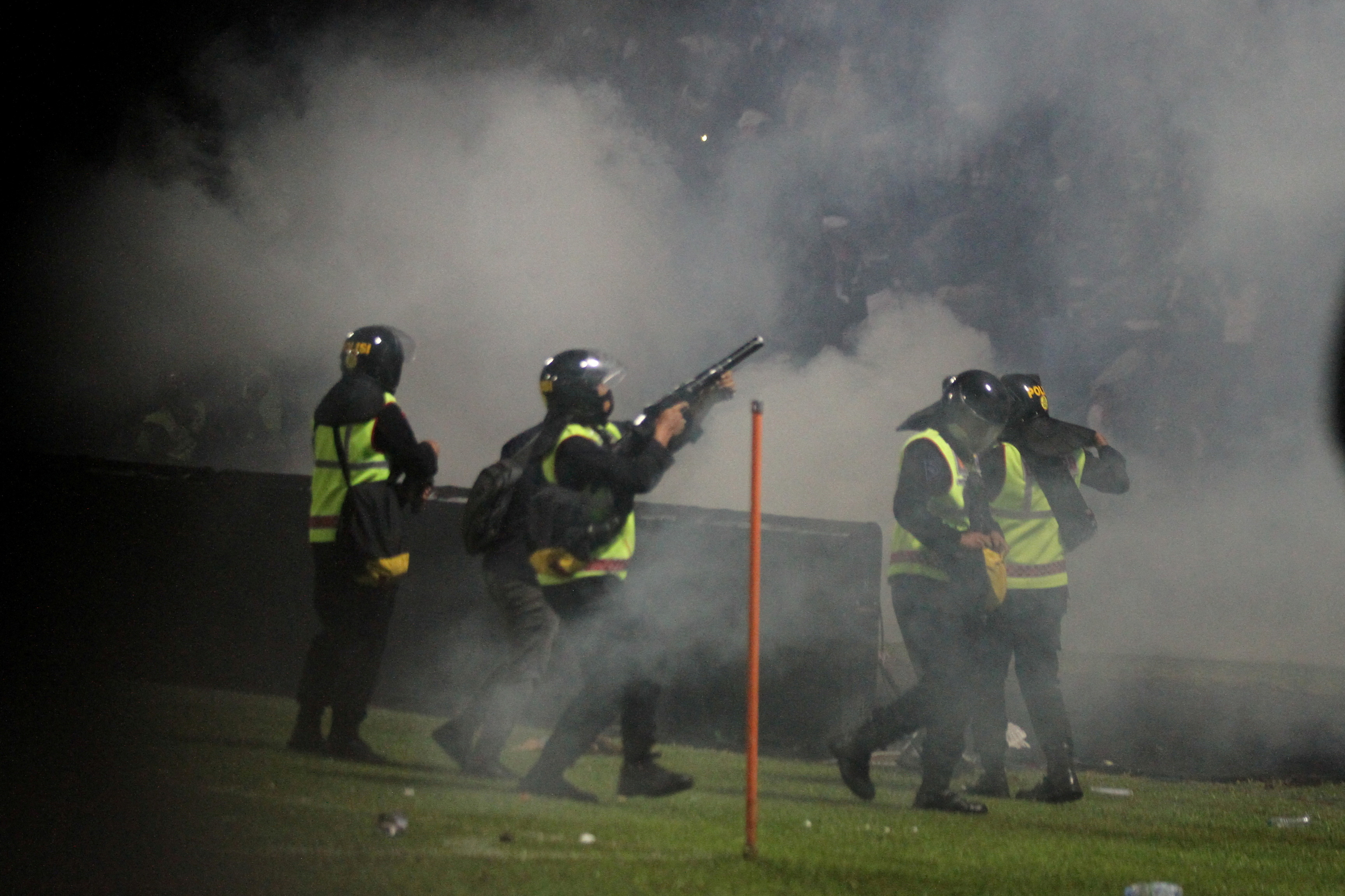 A riot police officer fires tear gas during a riot after the league BRI Liga 1 football match between Arema vs Persebaya at Kanjuruhan Stadium in Malang, East Java province, Indonesia, October 2, 2022.
