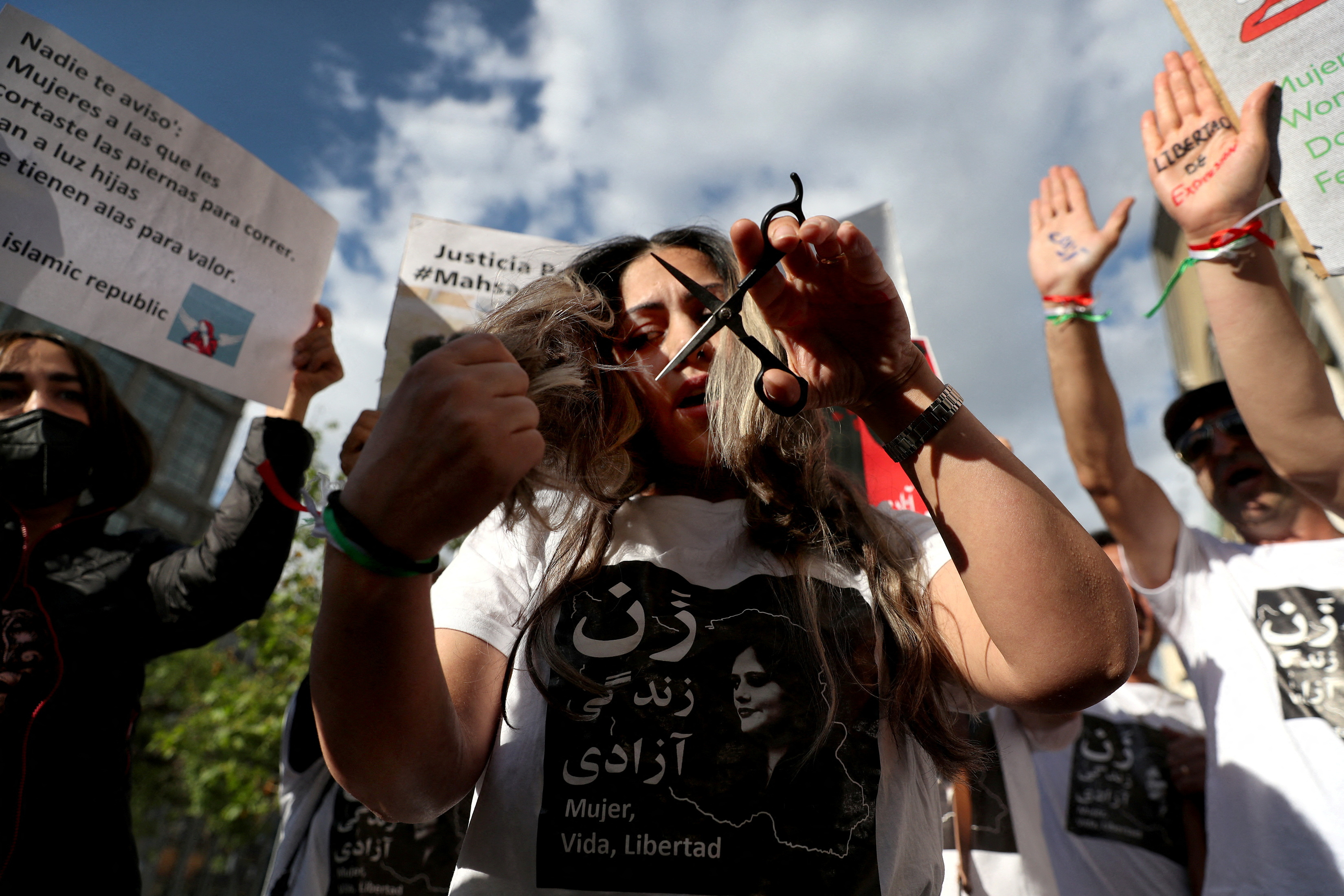 A woman cuts her hair as Iranian community members living in Chile attend a rally in solidarity with Iranian women, in Santiago, Chile, October 7, 2022.REUTERS/Ivan Alvarado TPX IMAGES OF THE DAY