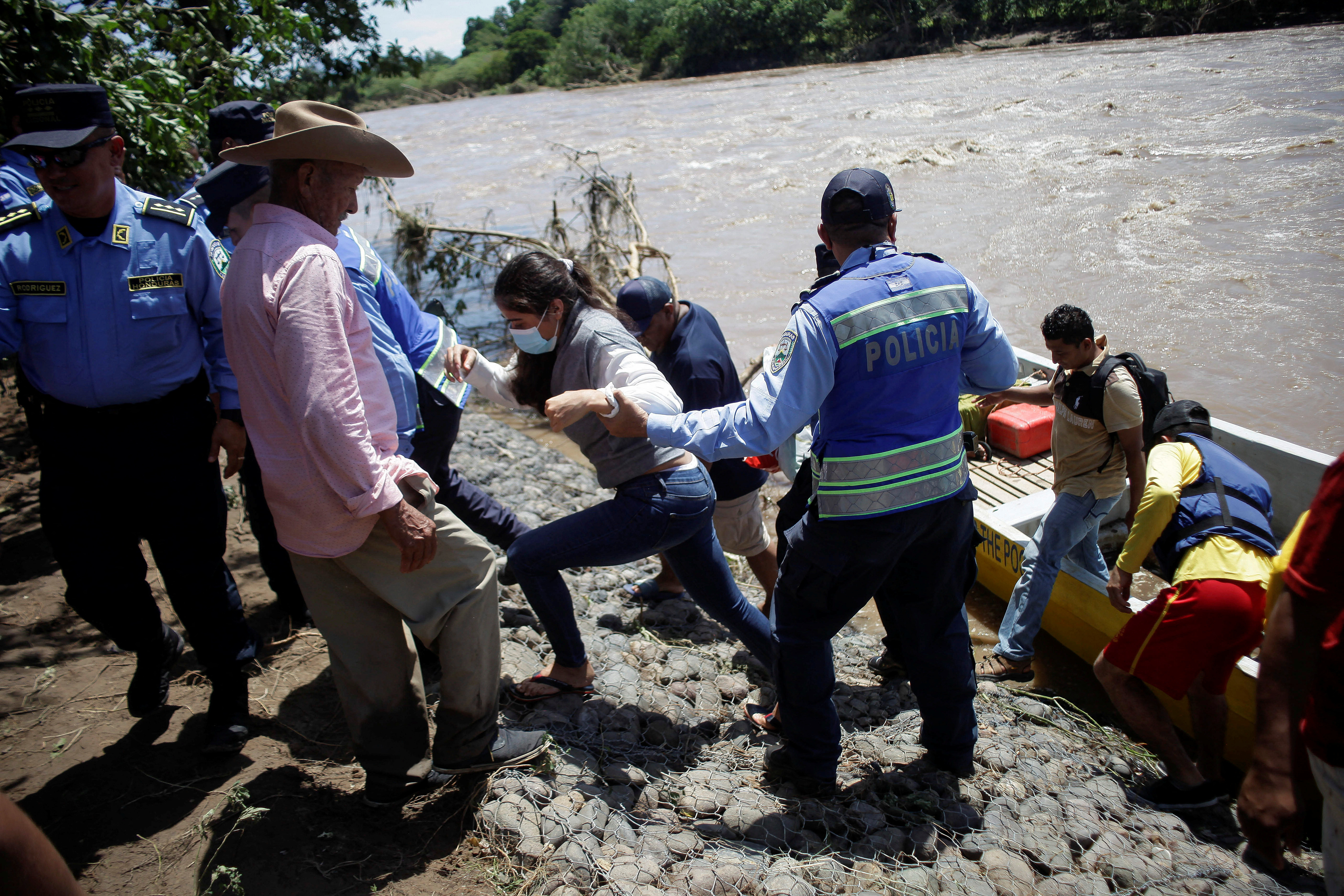 Police officers help people affected by tropical storm Julia in Honduras.