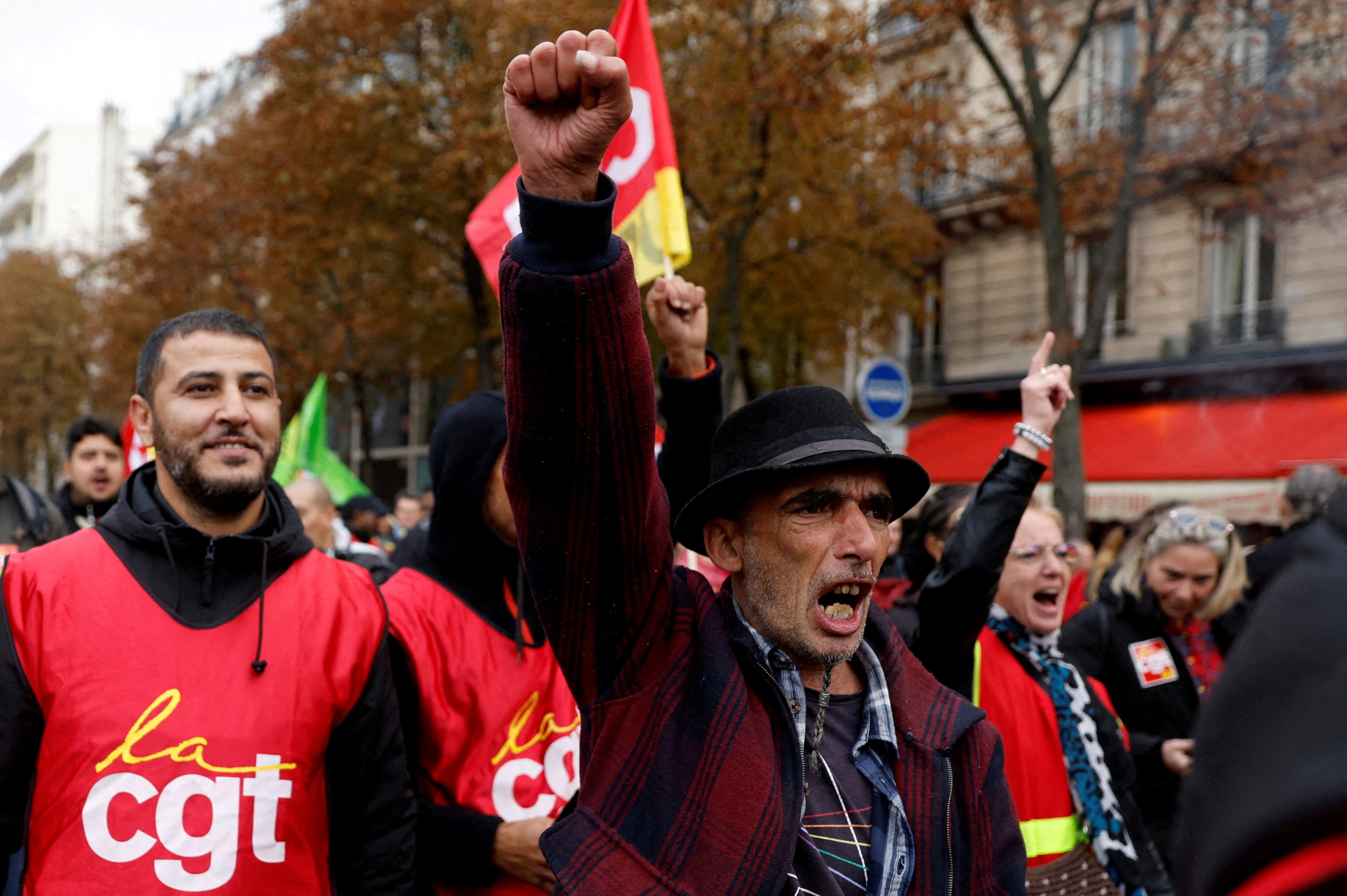 Protesters, some in red CGT vests, march through the streets of Paris in protest at the surging cost of living