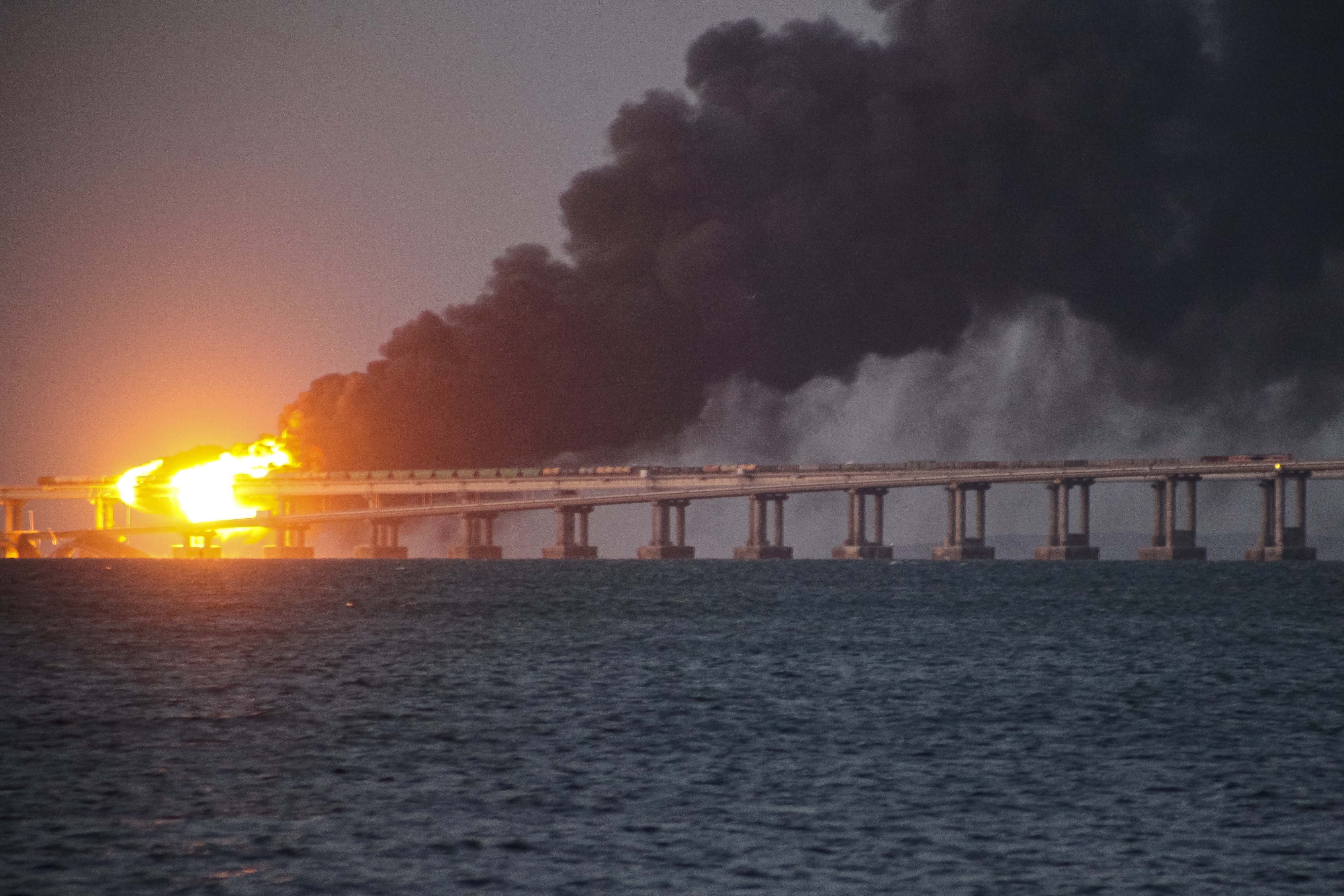 Flame and smoke rise from the Crimean bridge connecting Russian mainland and Crimean Peninsula over the Kerch Strait