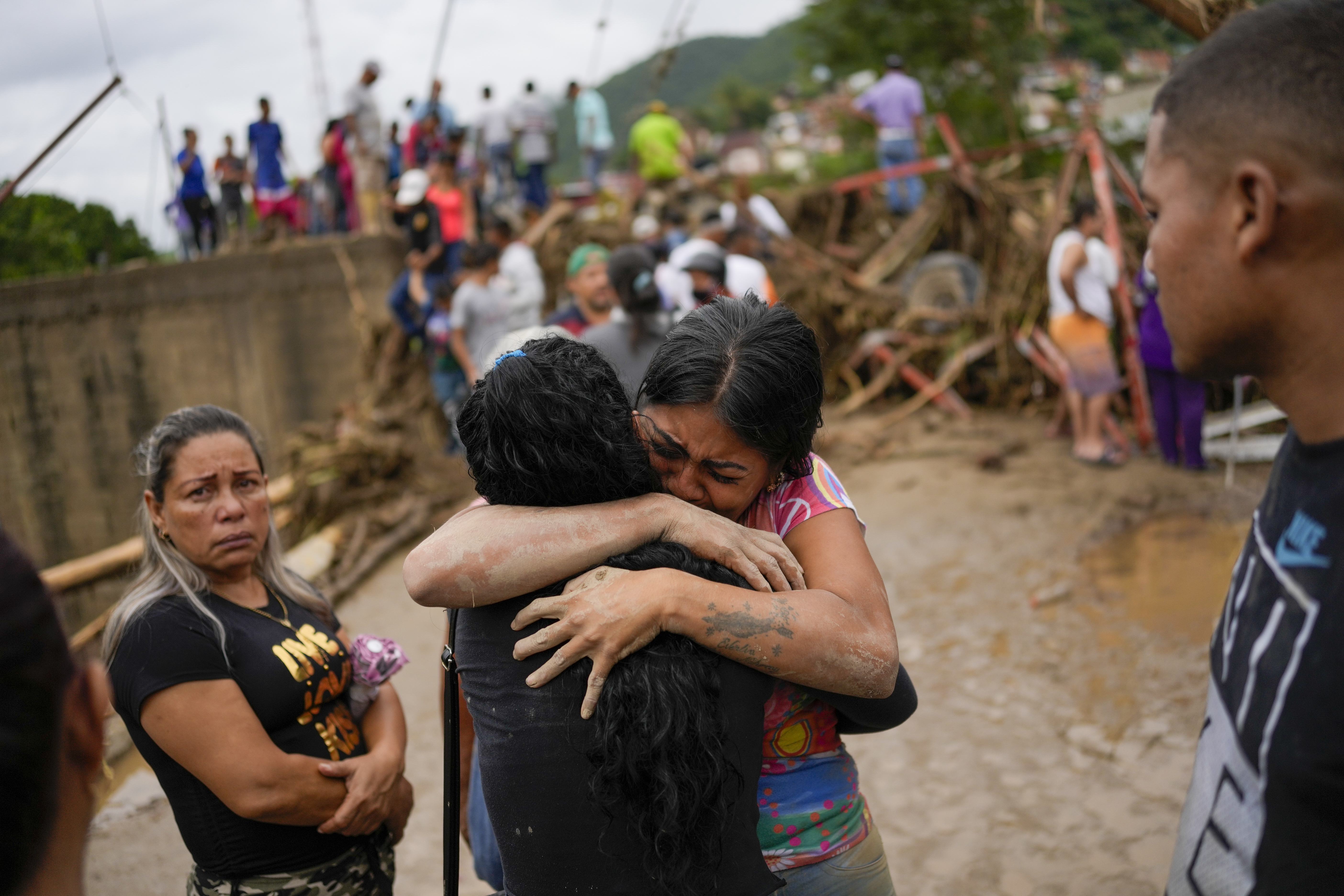 Distraught residents hug each other amid the devastation of the landslide in Venezuela.