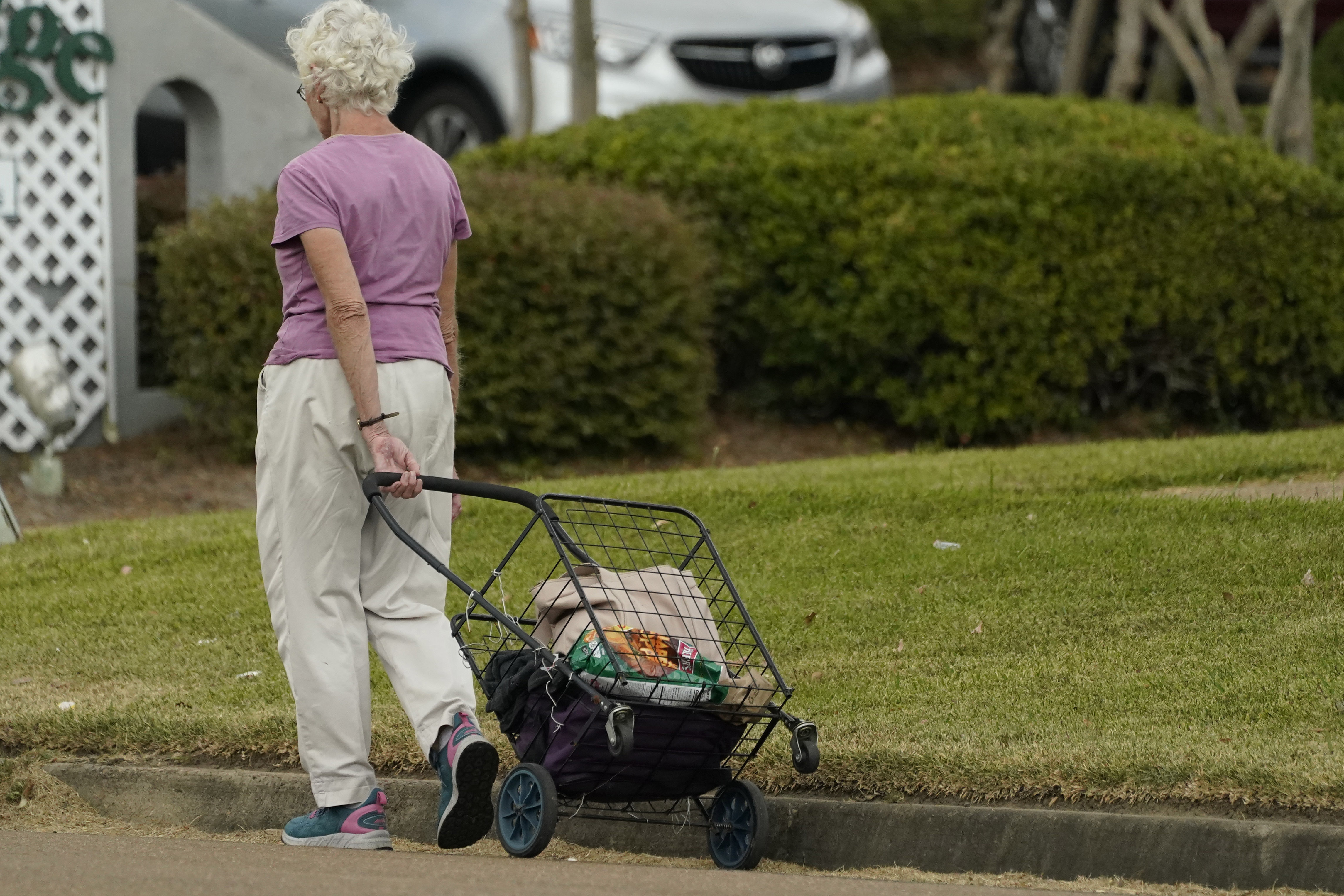 An older customer walks home after shopping in Jackson, Miss.