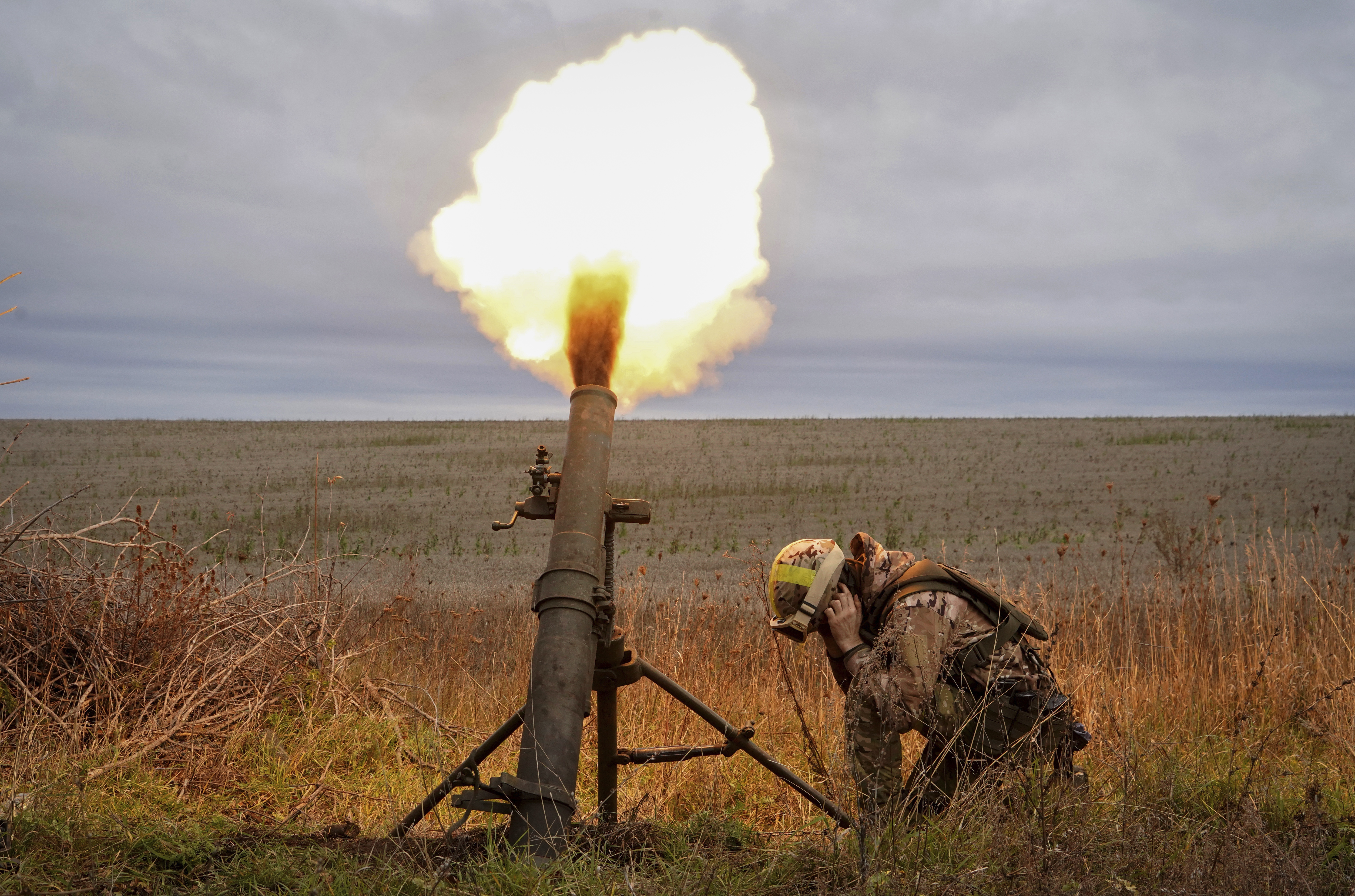 Ukrainian National guard soldiers fire at Russian positions with a mortar near Kharkiv, Ukraine