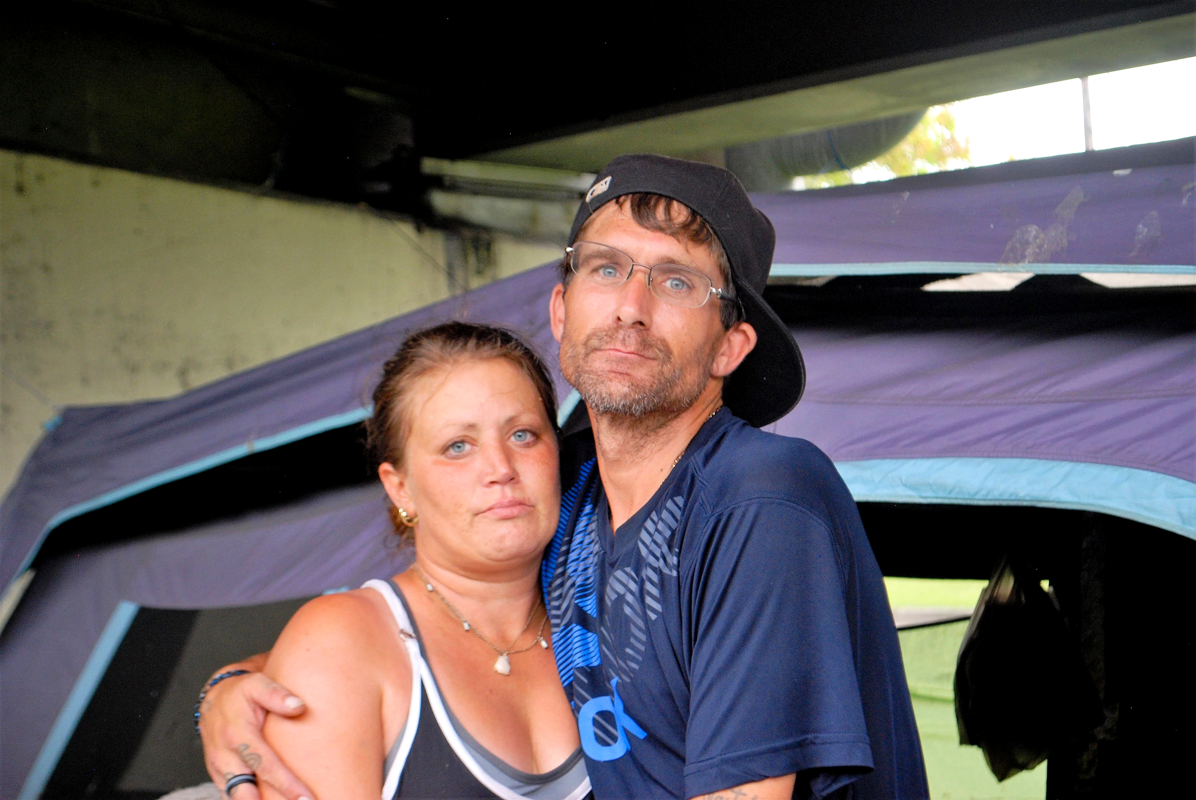 Jessica and Terry, their arms around each other, in front of their tent.