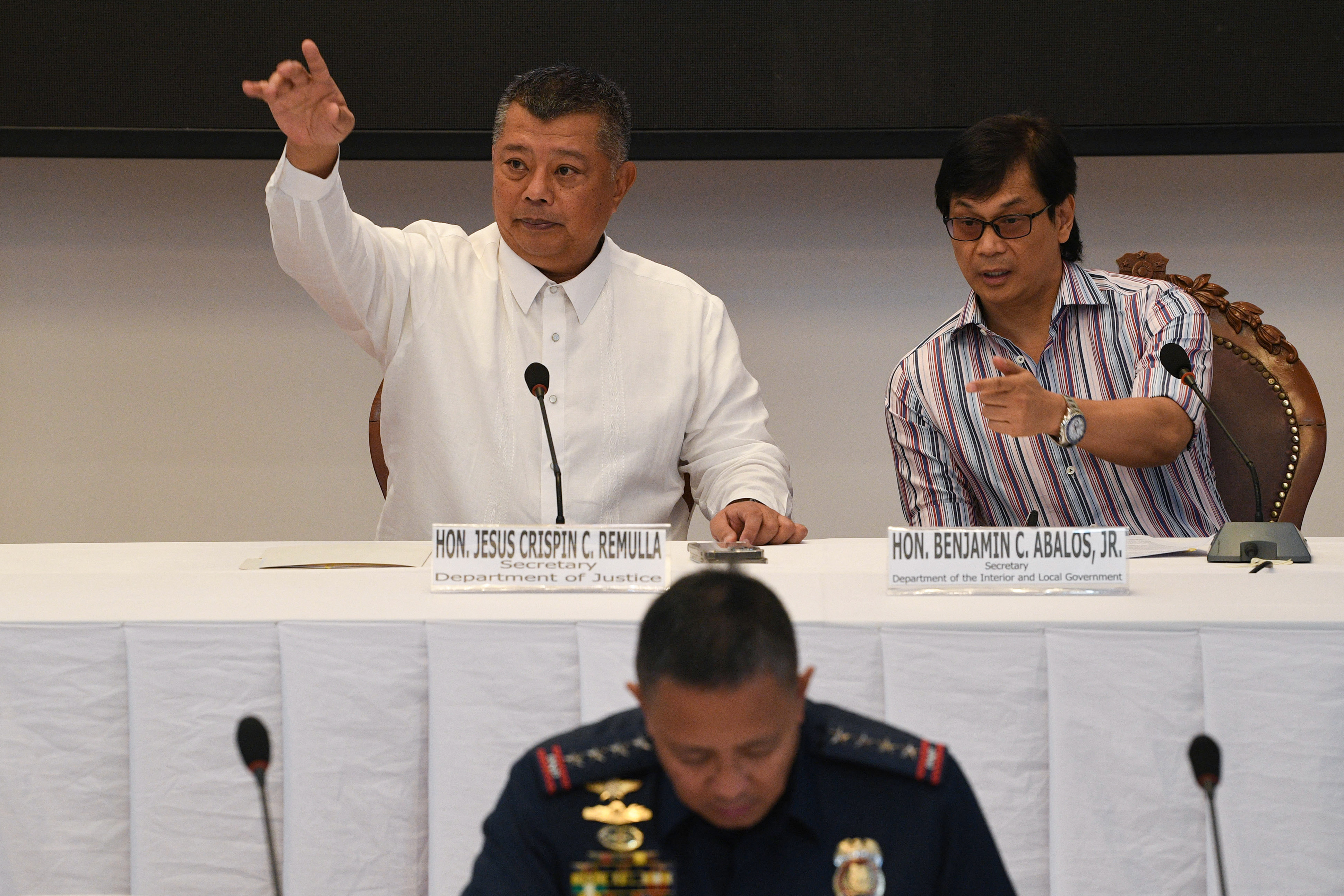 Philippines' Secretary of Interior Benjamin Abalos Jr., (R) gestures with Philippines' Justice Secretary Jesus Remulla (L) during a press conference announcing suspects in the killing of radio journalist Percival Mabasa, at the Department of Justice in Manila on November 7, 2022