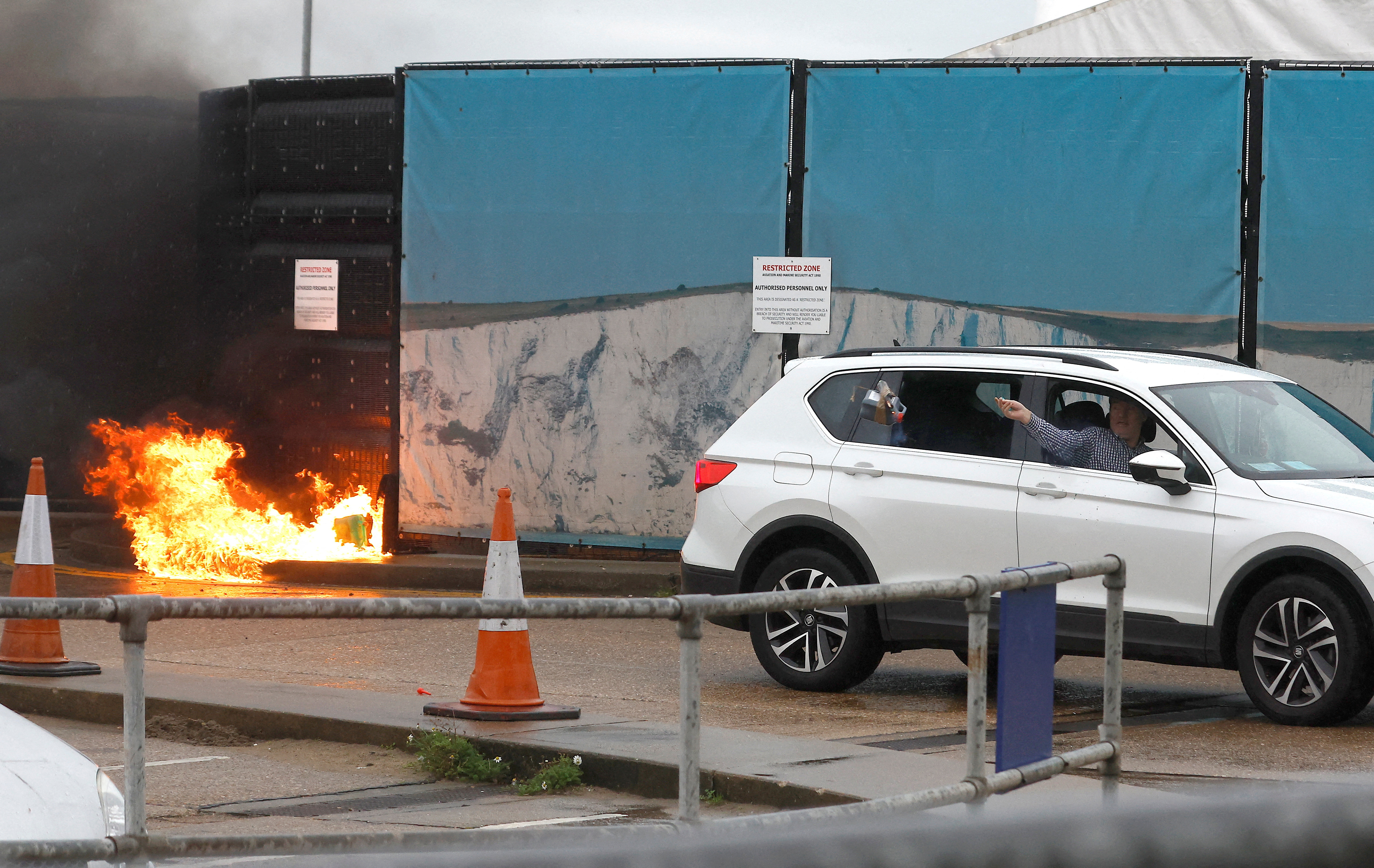 A man throws an object out of a car window