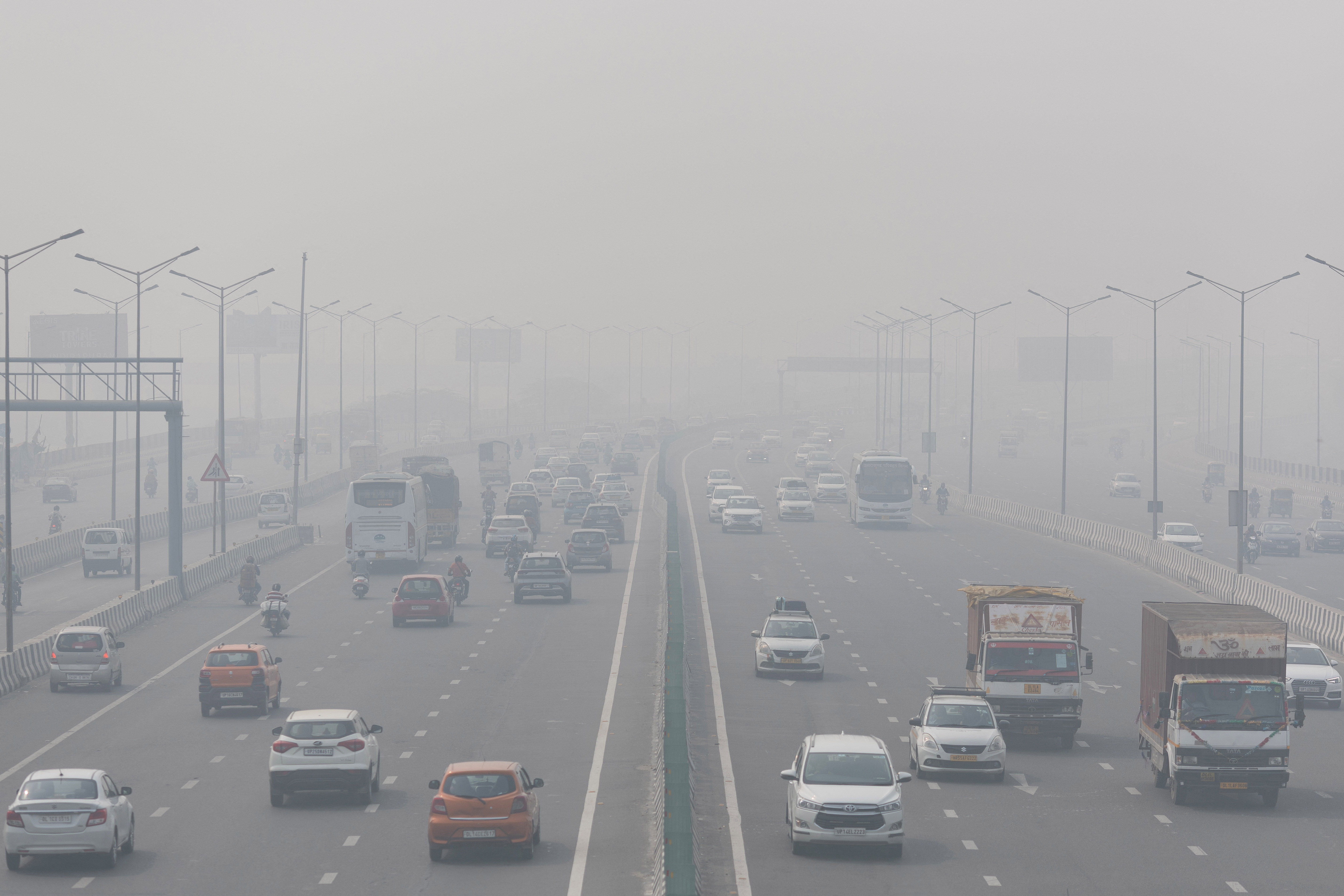 Traffic moves along a highway shrouded in heavy smog in New Delhi.