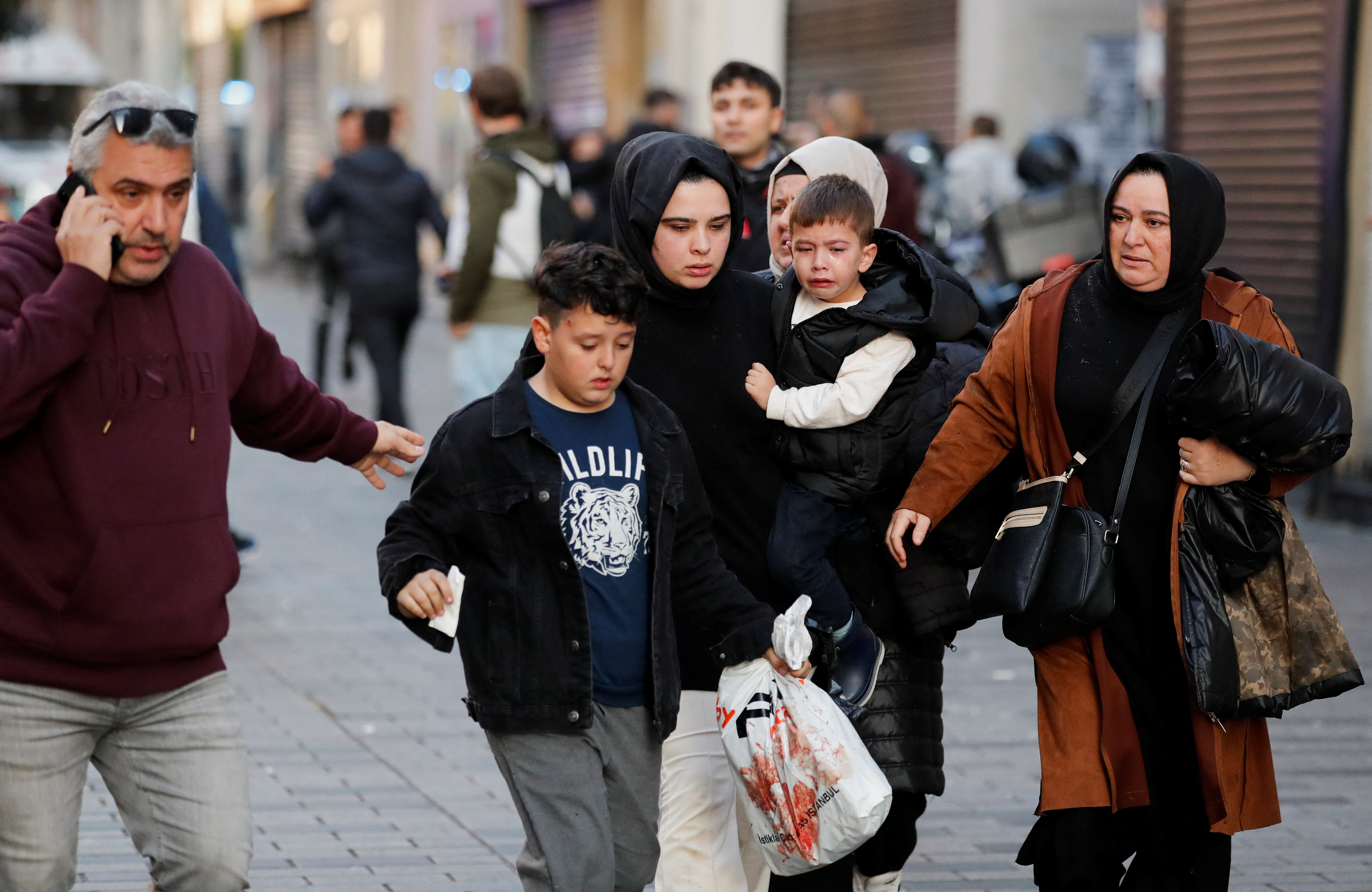 People react after an explosion on busy pedestrian Istiklal street in Istanbul.