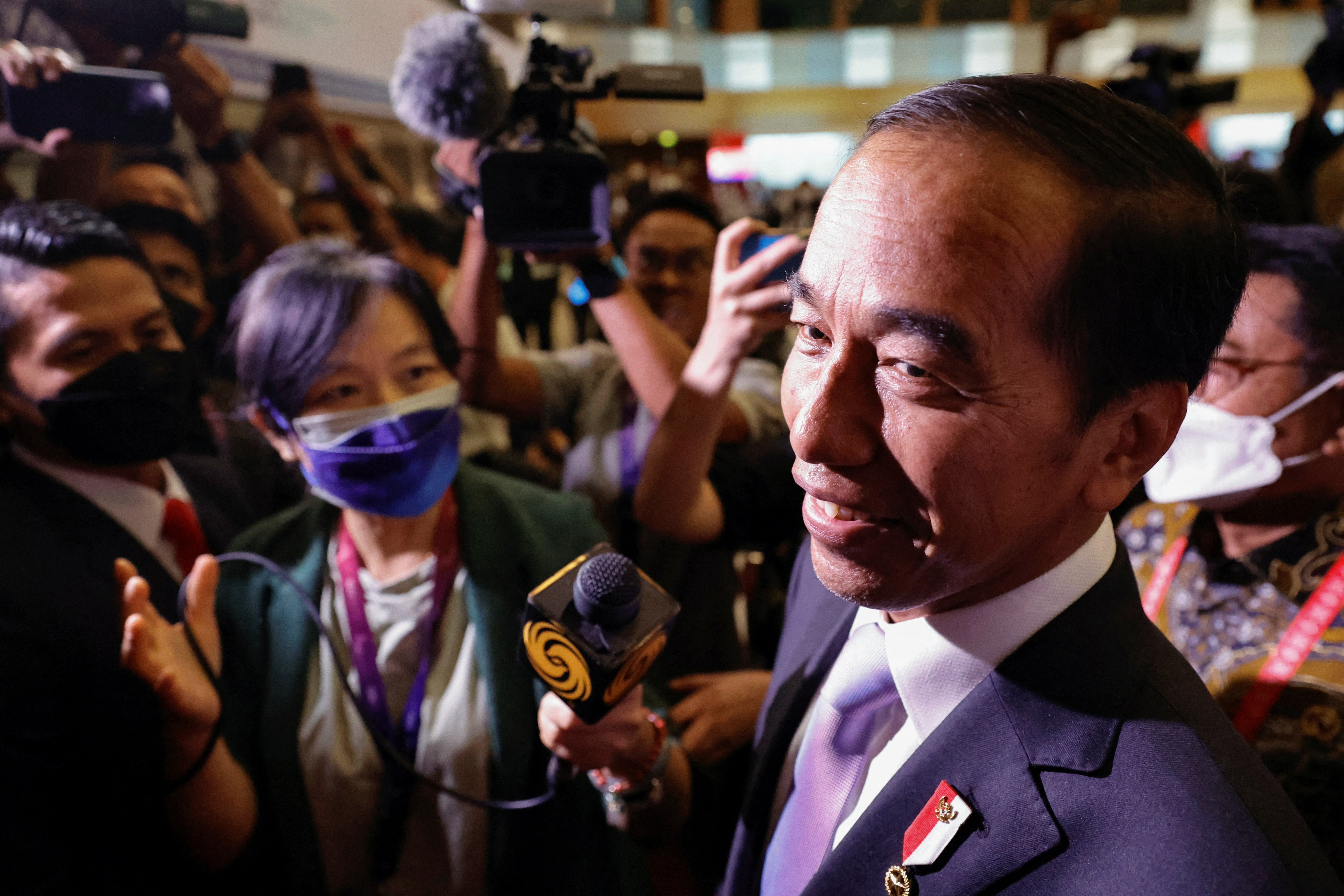 Indonesian President Joko Widodo smiling as he is surrounded by journalists during a visit to the G20 media centre in Bali, Indonesia.