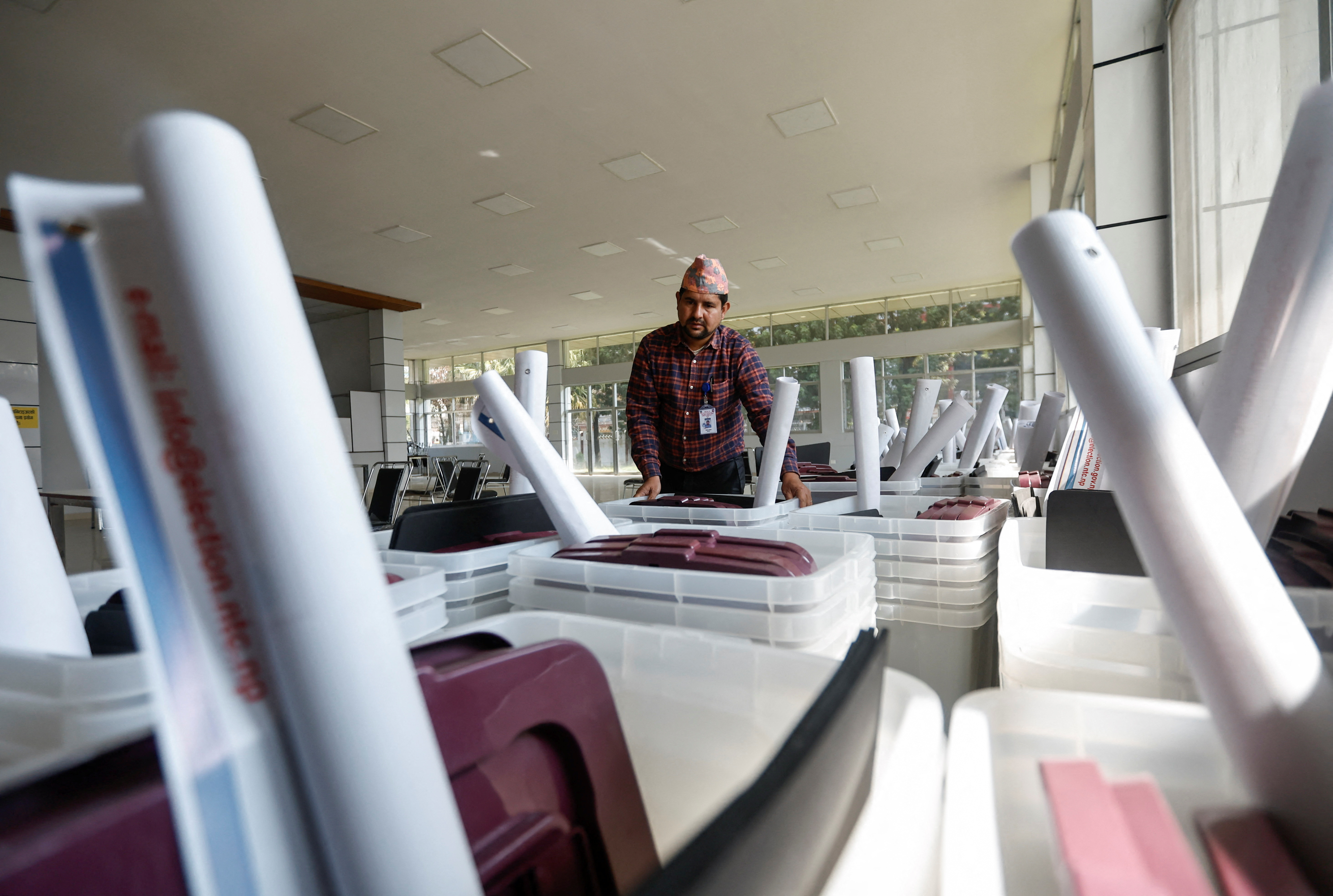 An official from the election commission checks ballot boxes before distributing them ahead of the general elections, in Kathmandu, Nepal