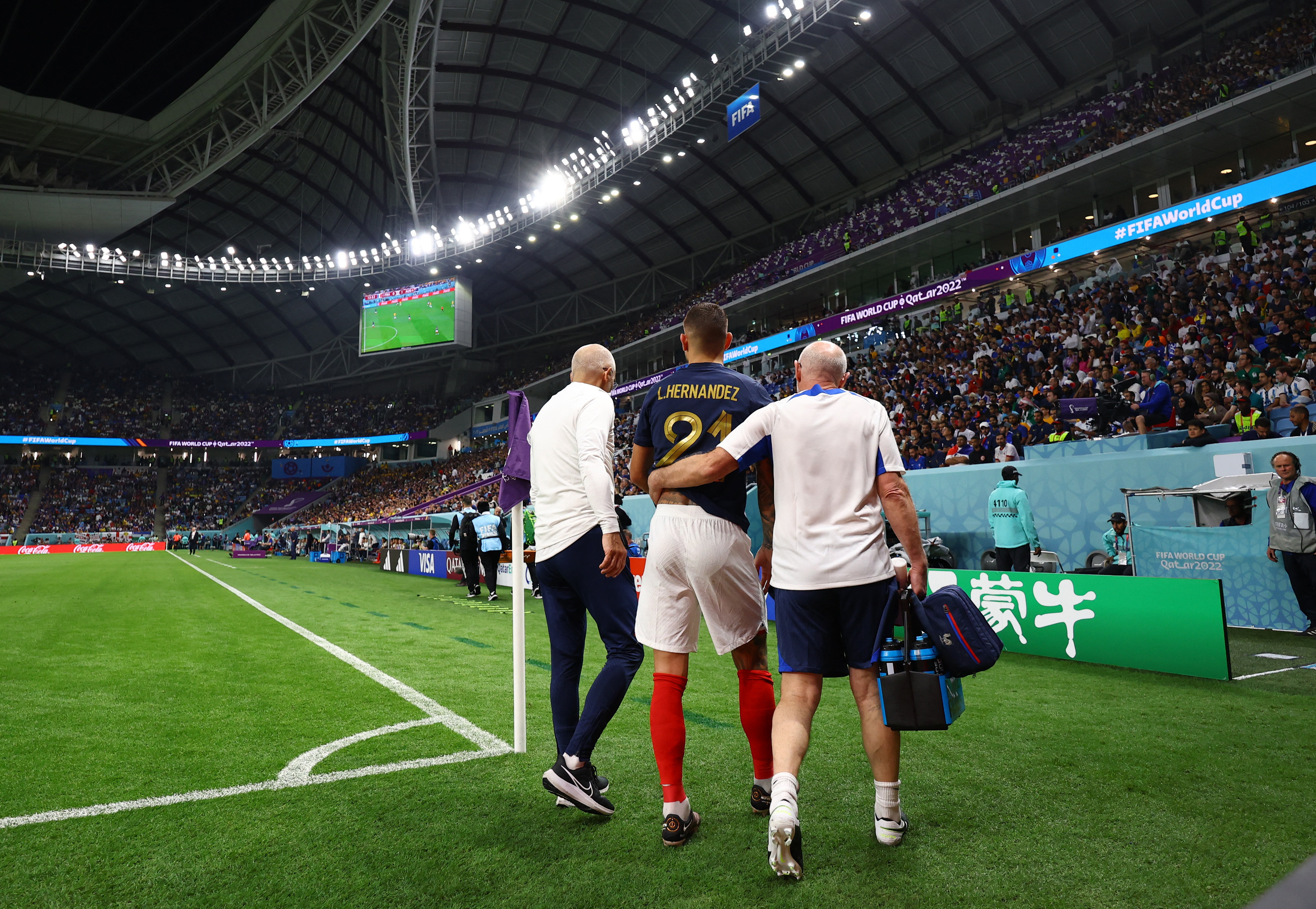 Hernandez from the back flanked by two medics, one with his arm around him
