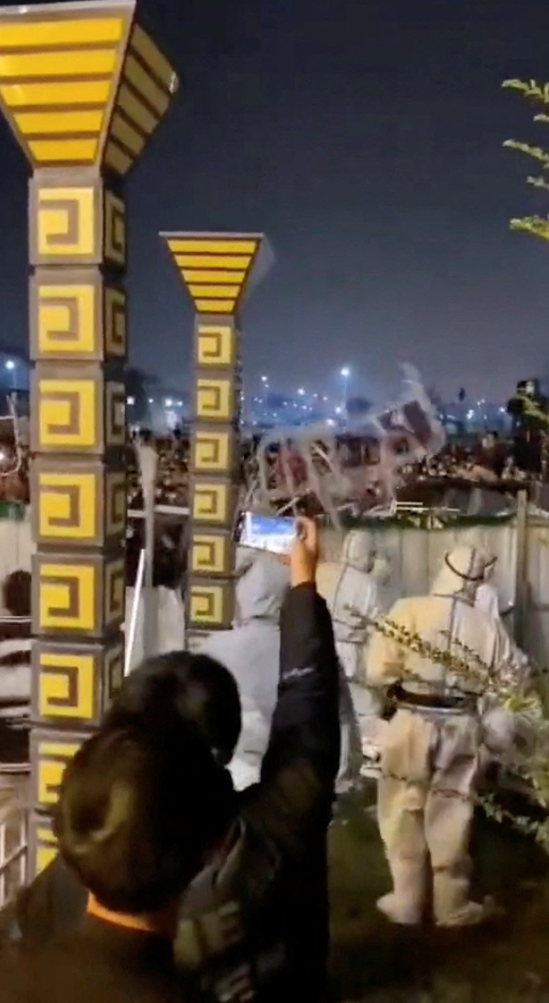 People throw objects at security forces during a protest near Apple supplier Foxconn's factory in Zhengzhou, China.