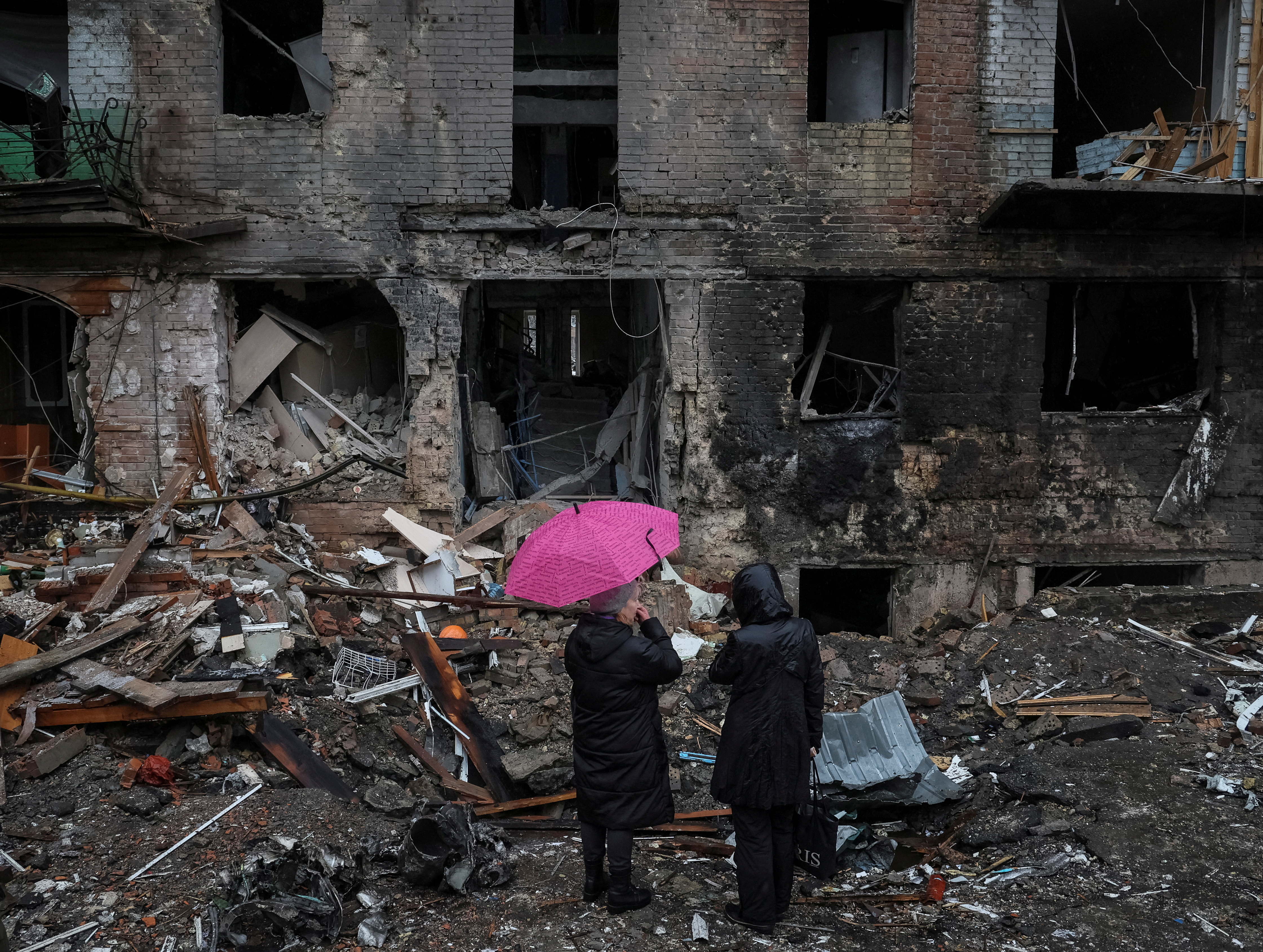 Residents stand near their building destroyed by a Russian missile attack in the town of Vyshhorod, near Kyiv, Ukraine.