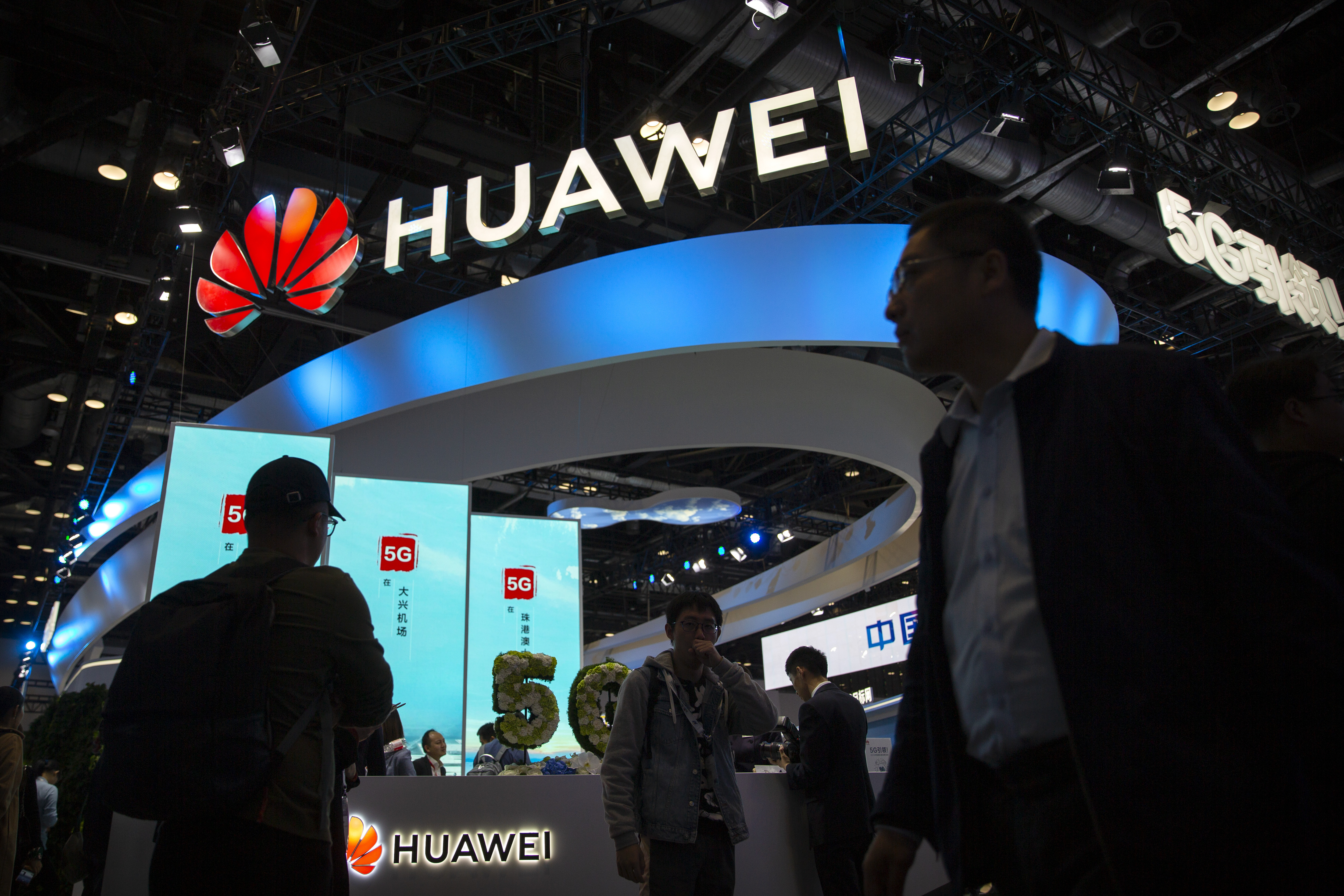 People file past a stall advertising Huawei at the PT Expo in Beijing