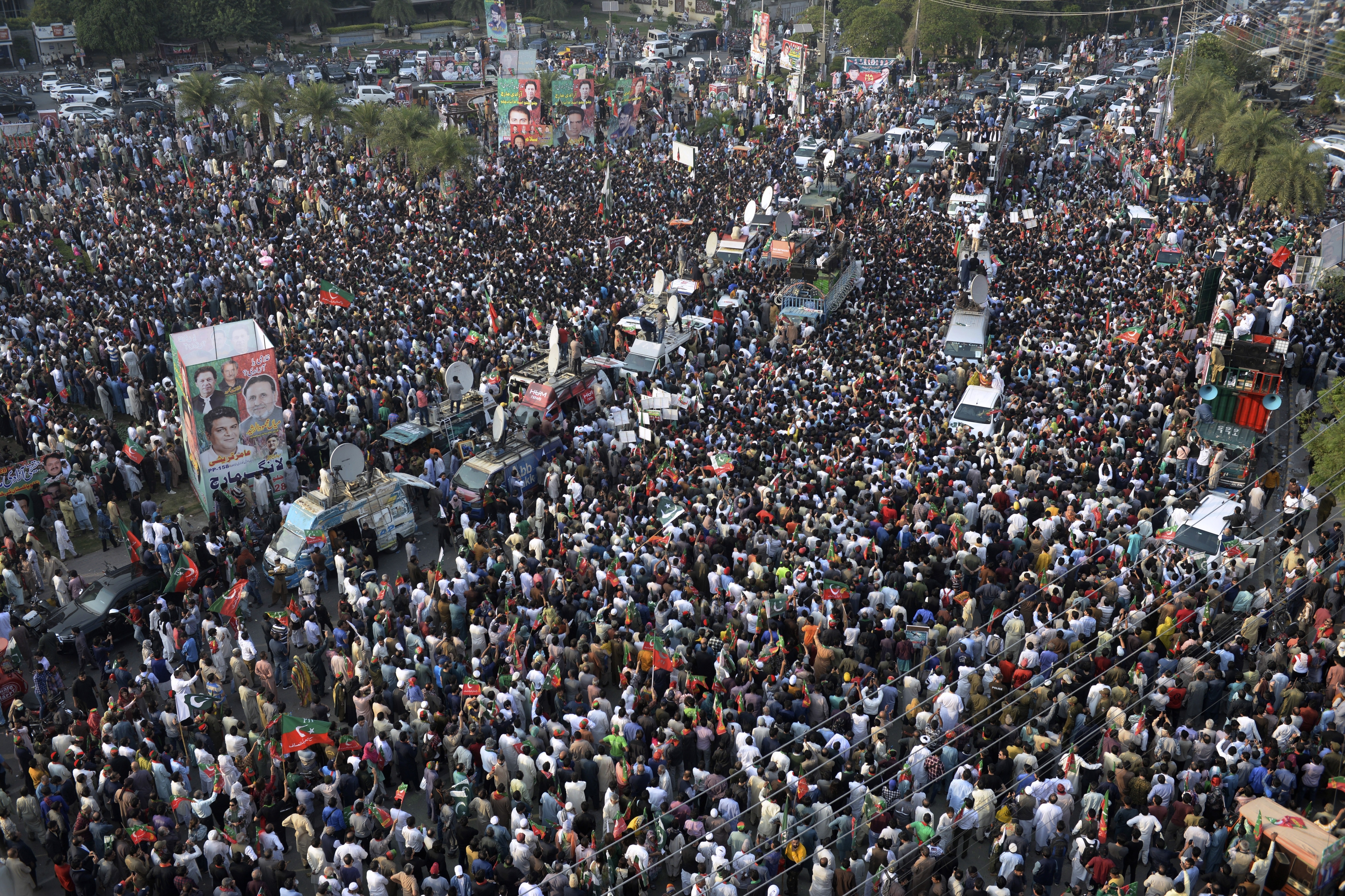 Supporters of Pakistan's main opposition 'Tehreek-e-Insaf party' listen to Imran Khan at a rally in Lahore, Pakistan