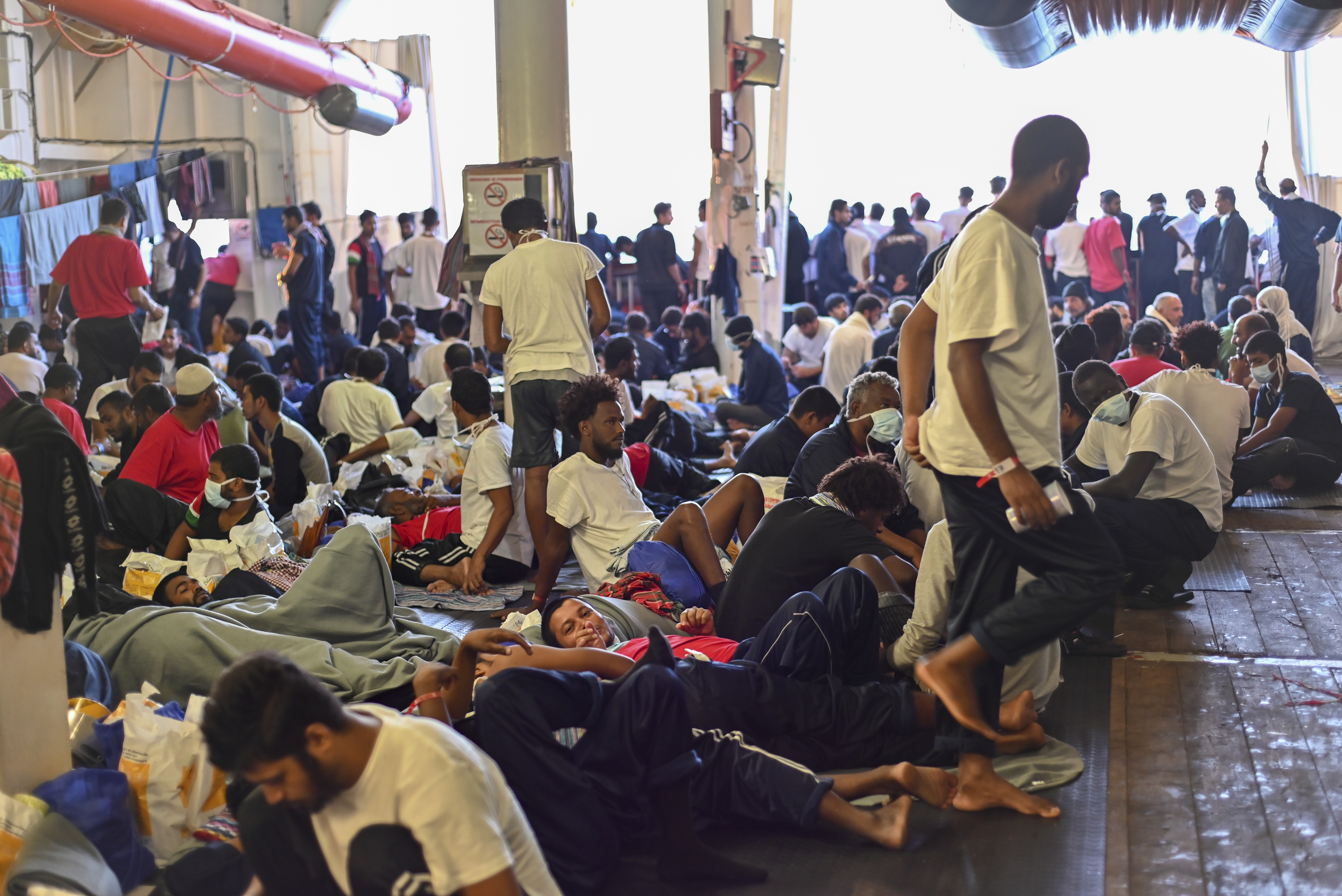 Migrantes rescatados por el barco de la ONG Geo Barents, en la cubierta del barco que navega en el mar Mediterráneo.