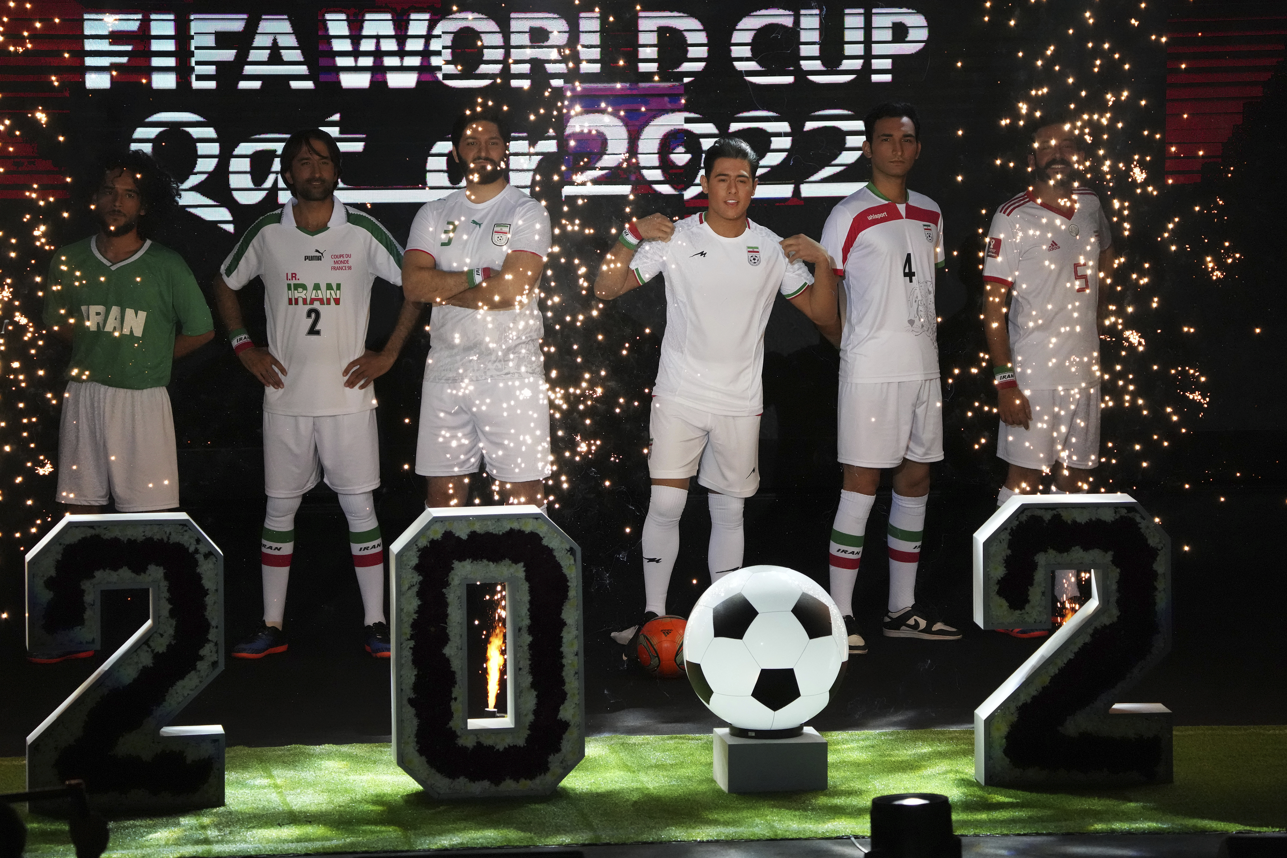 A model wears the Iranian national football team's new kit, third right, for the upcoming 2022 World Cup