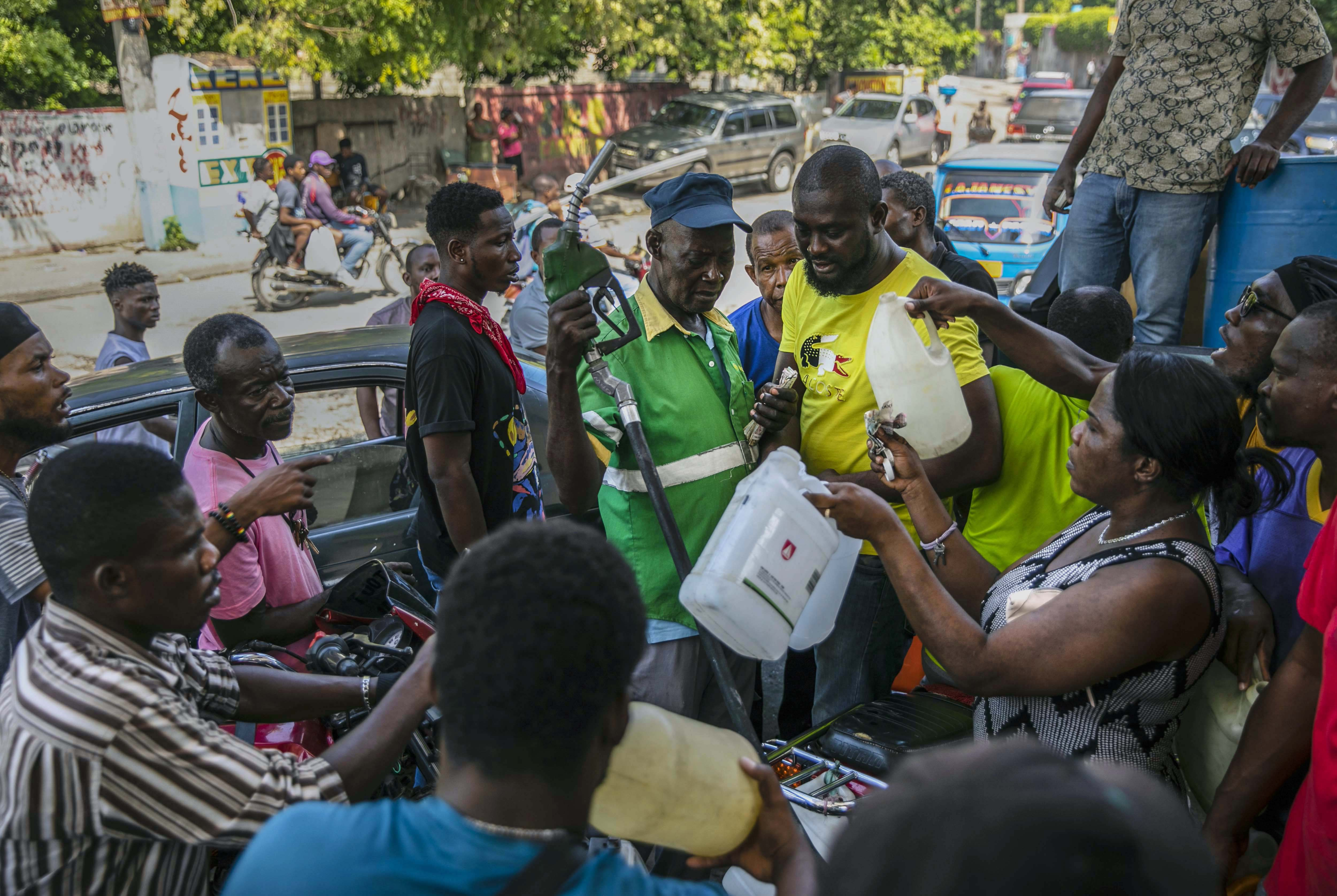 People crowd around a gas pump in Port-au-Prince, Haiti