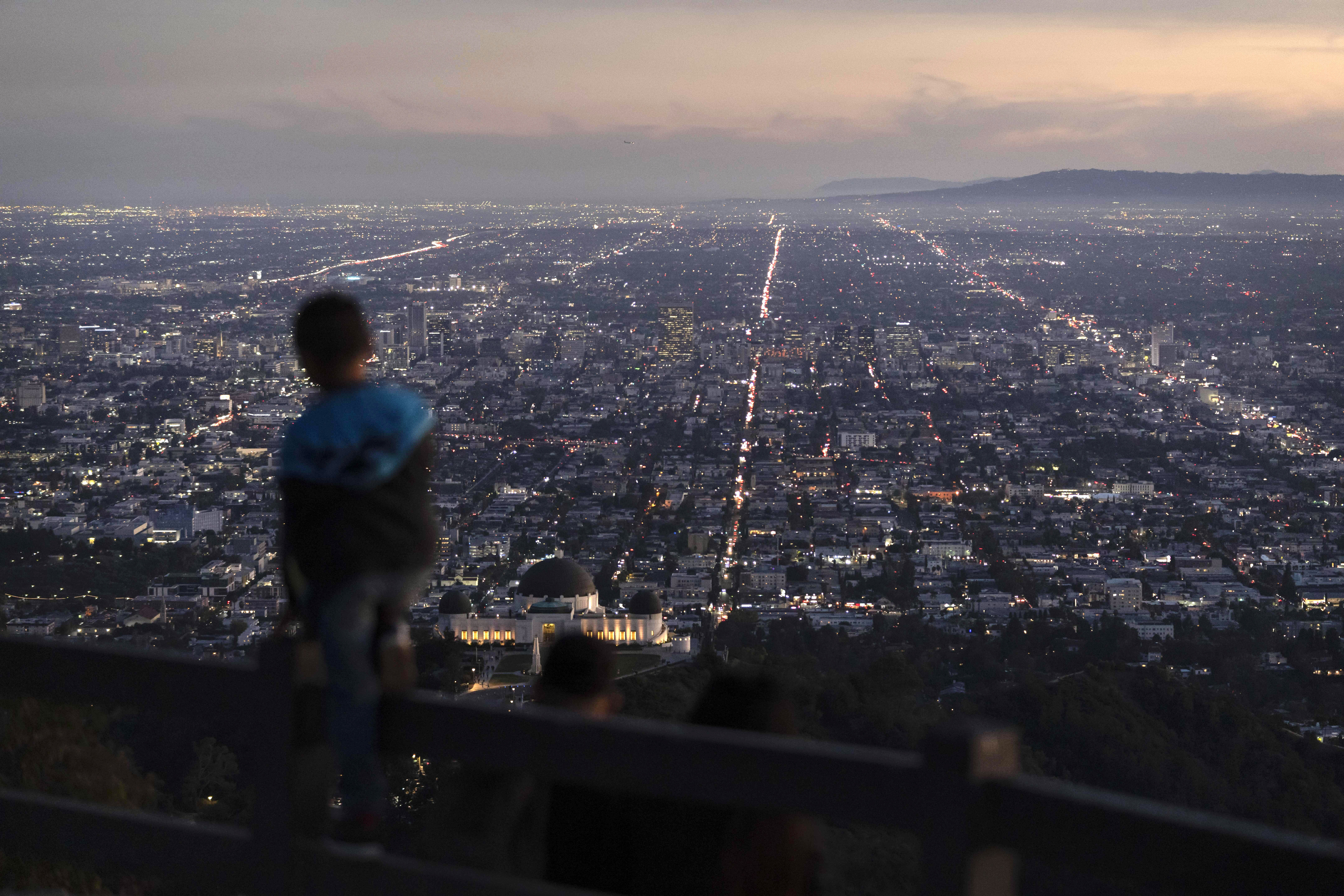 A boy takes in the view of the Los Angeles skyline from the Griffith Park Observatory Trails Peak in Los Angeles