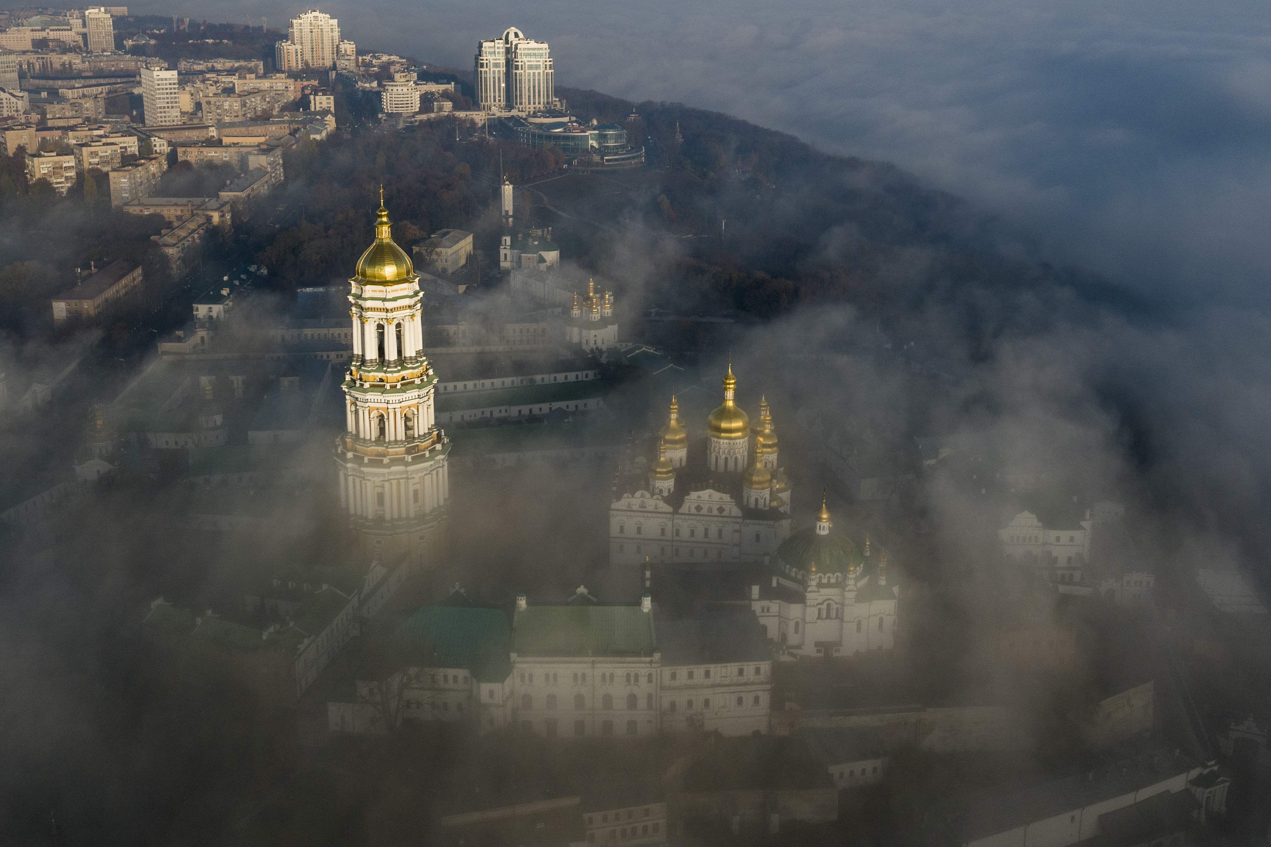 An aerial view of the Kyiv Pechersk Lavra with its golden domes poking through mist