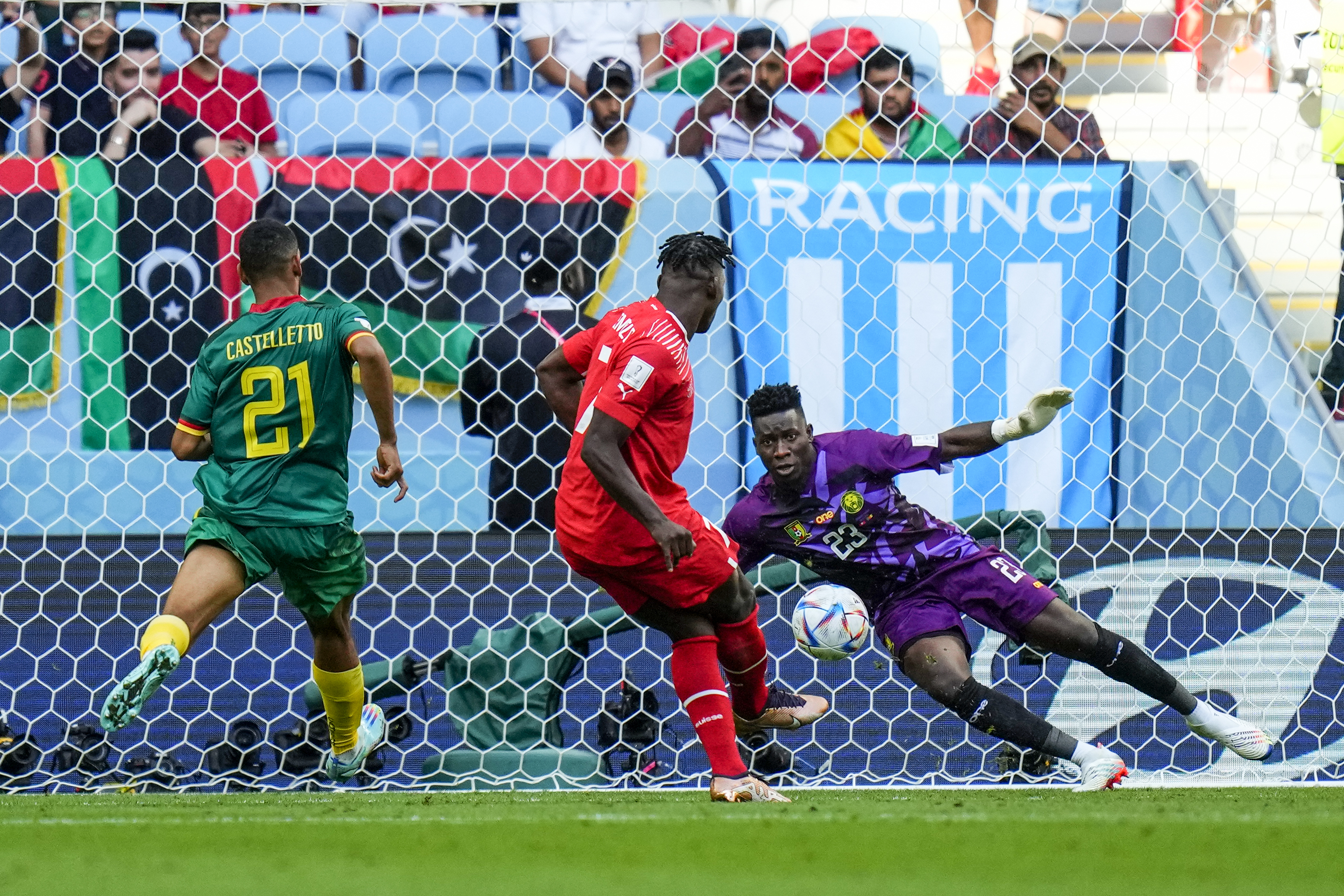 Embolo scoring his goal for Switzerland with Cameroon keeper jumping sideways to block it