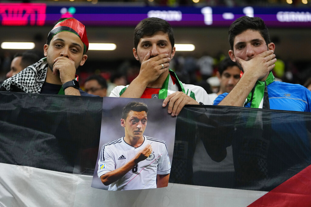 Spectators hold photo of former German international Mesut Ozil on the stands at the end of the World Cup group E football match between Spain and Germany, at the Al Bayt Stadium in Al Khor , Qatar.