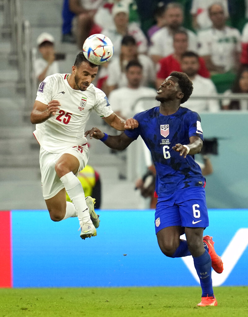 Jalali in mid air with the ball just coming off his head, with Musah at his side, staring at the ball intently, ready to pounce
