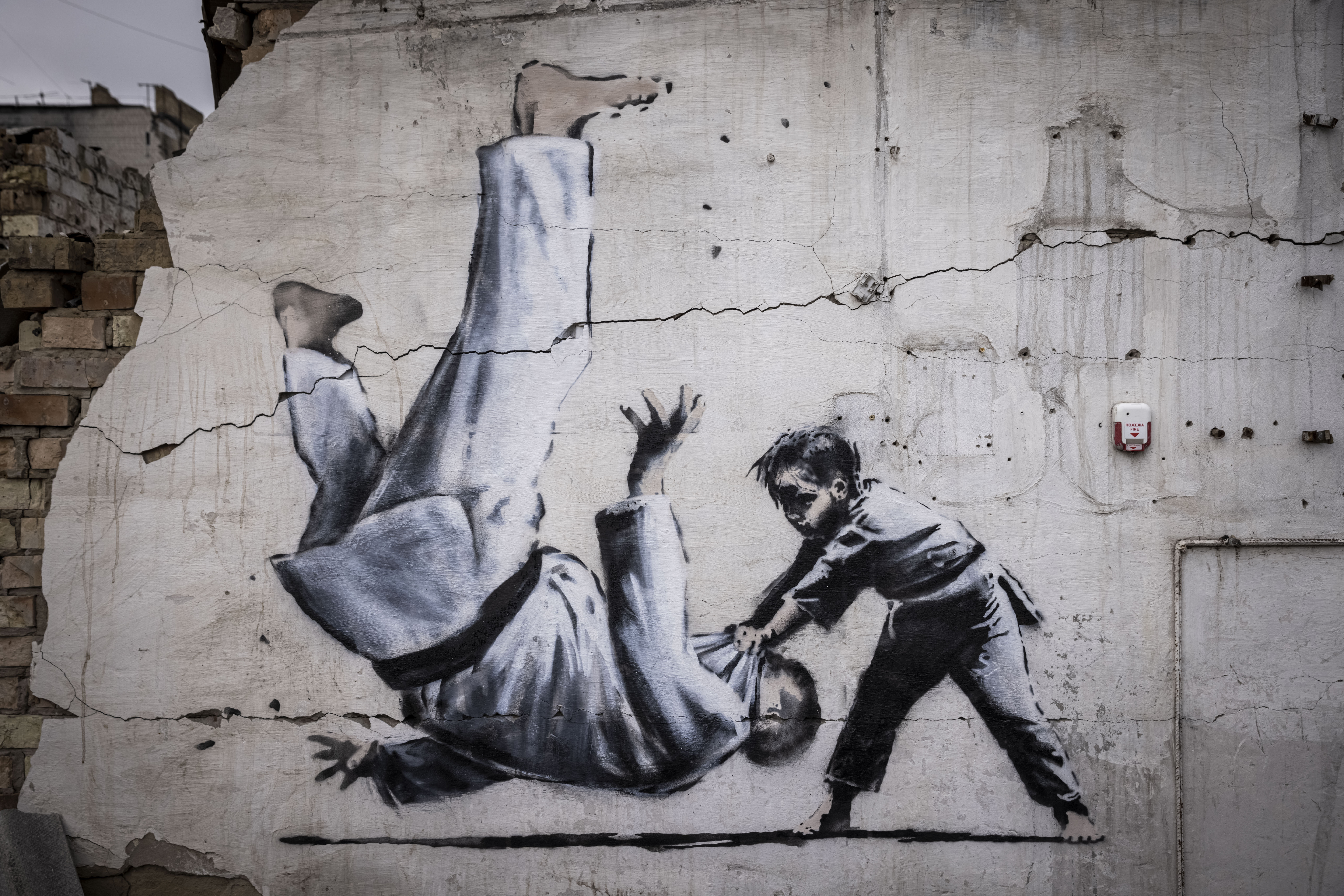 Graffiti of a child throwing a man on the floor in judo clothing 